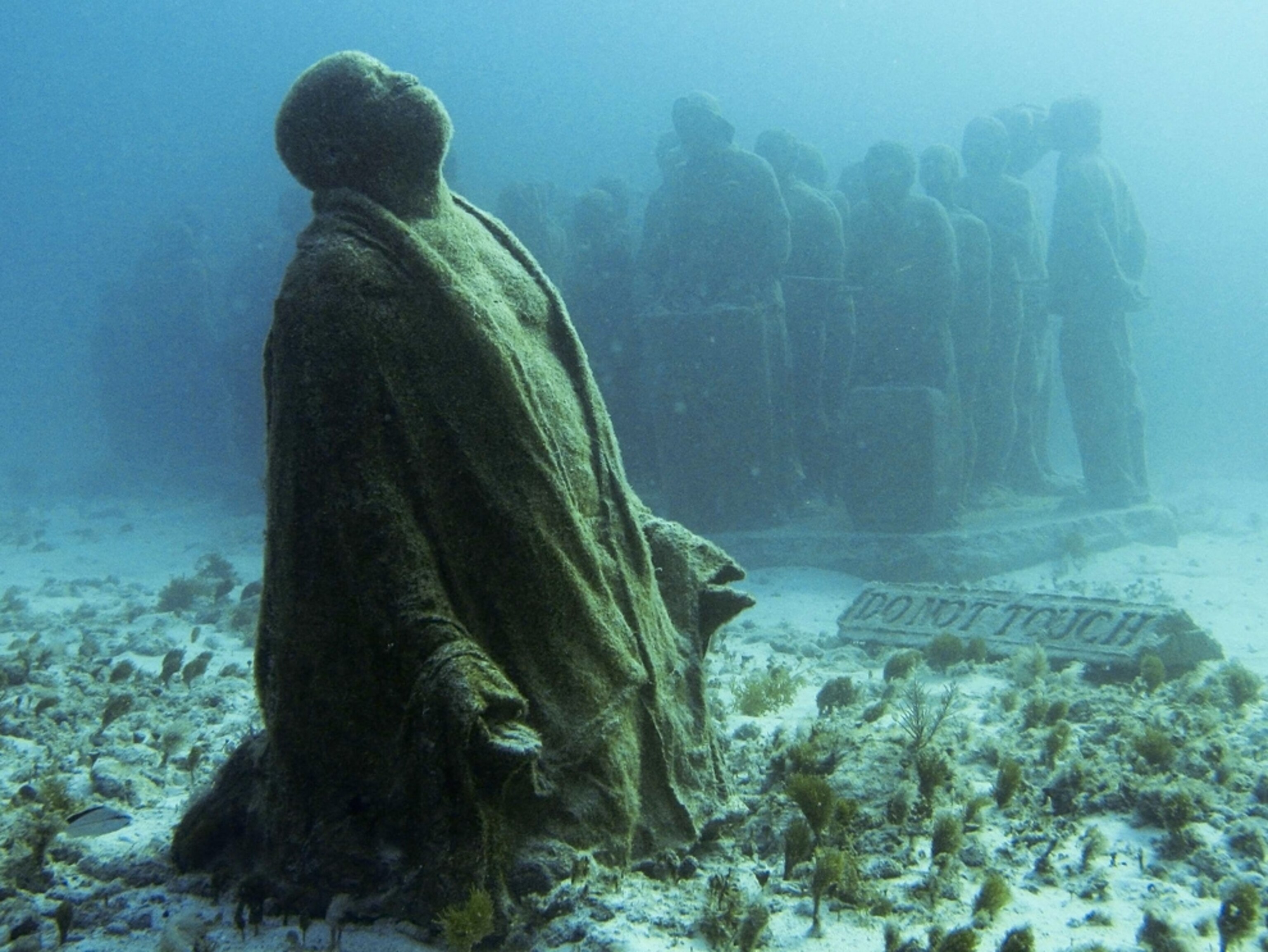 Kneeling underwater sculpture -- picture from photo gallery on "The Silent Evolution" Caribbean underwater sculpture park off Cancun, Mexico