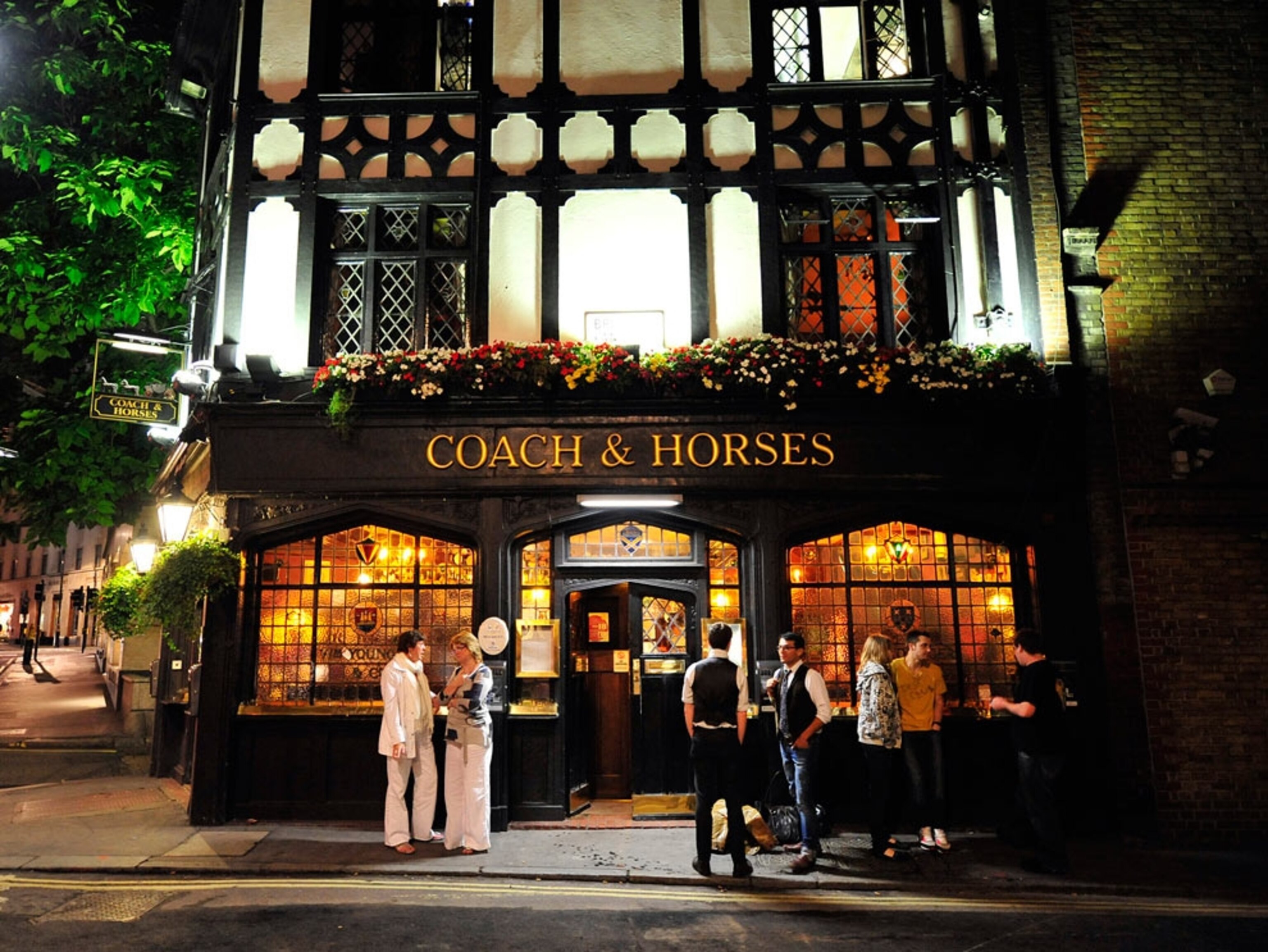 Patrons outside a pub at night