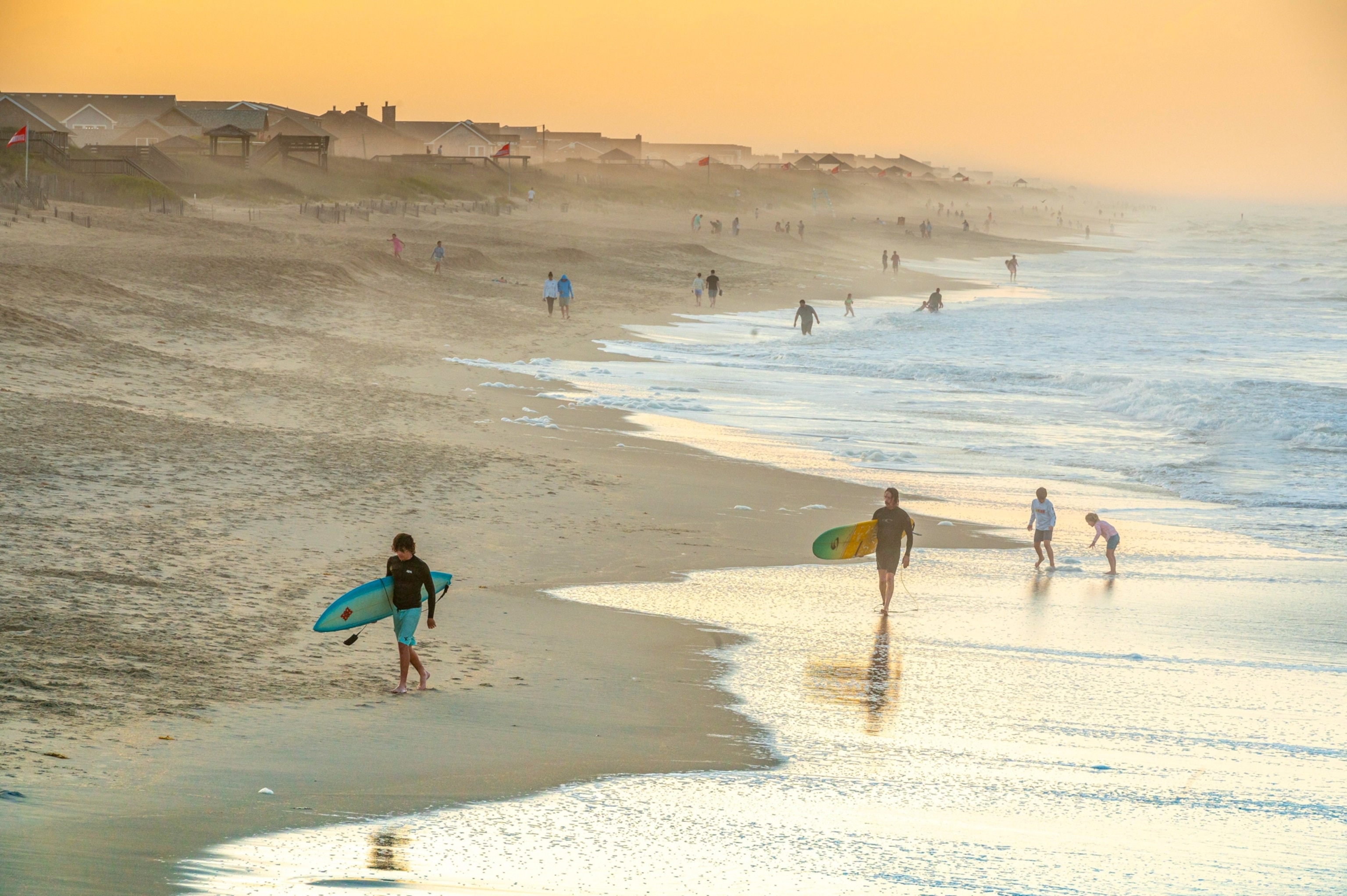 Surfers on the beach in front of the Nags Head Fishing pier, south of Kitty Hawk.