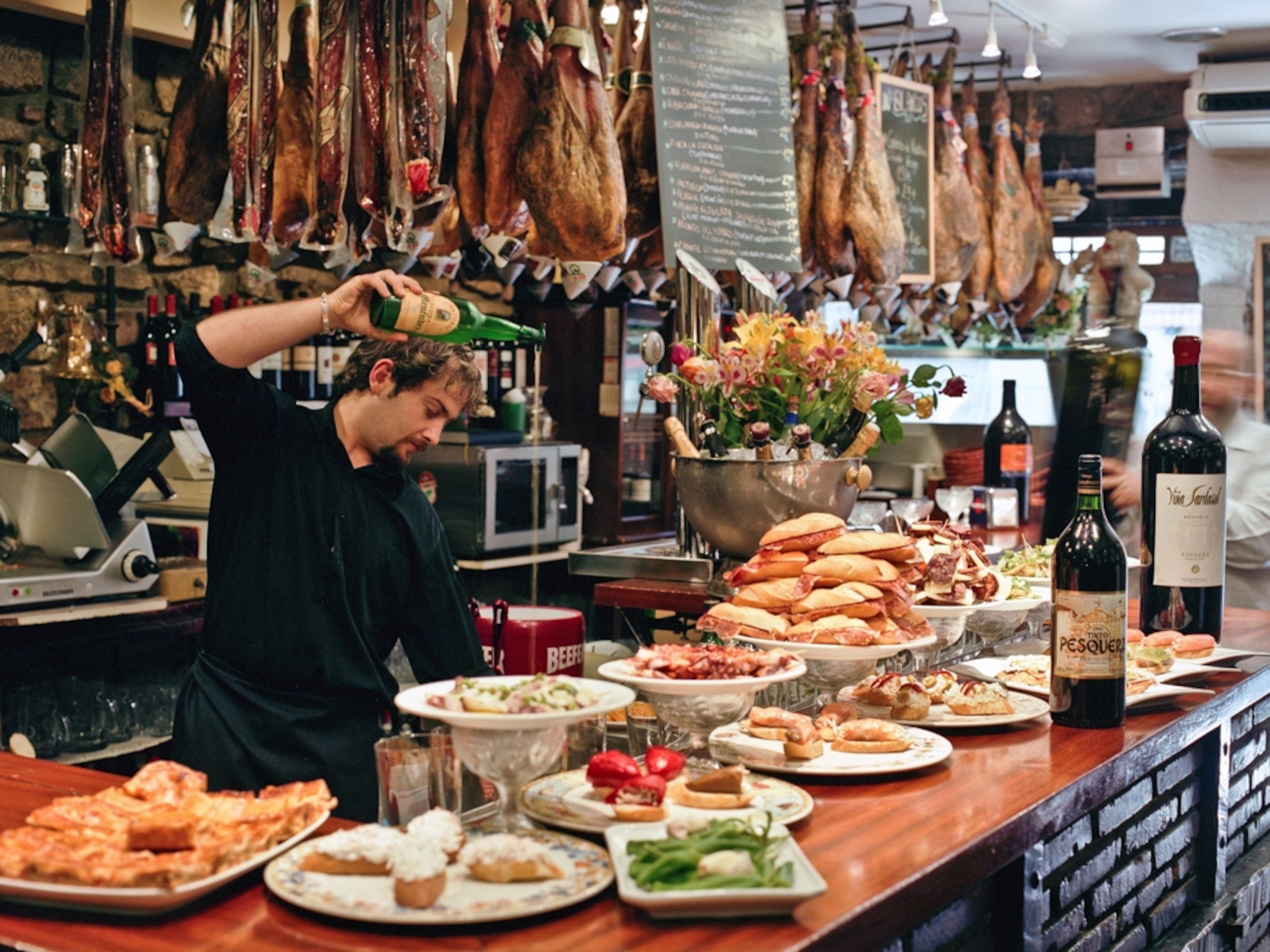 a bartender pouring a drink at a bar in San Sebastian, Spain.