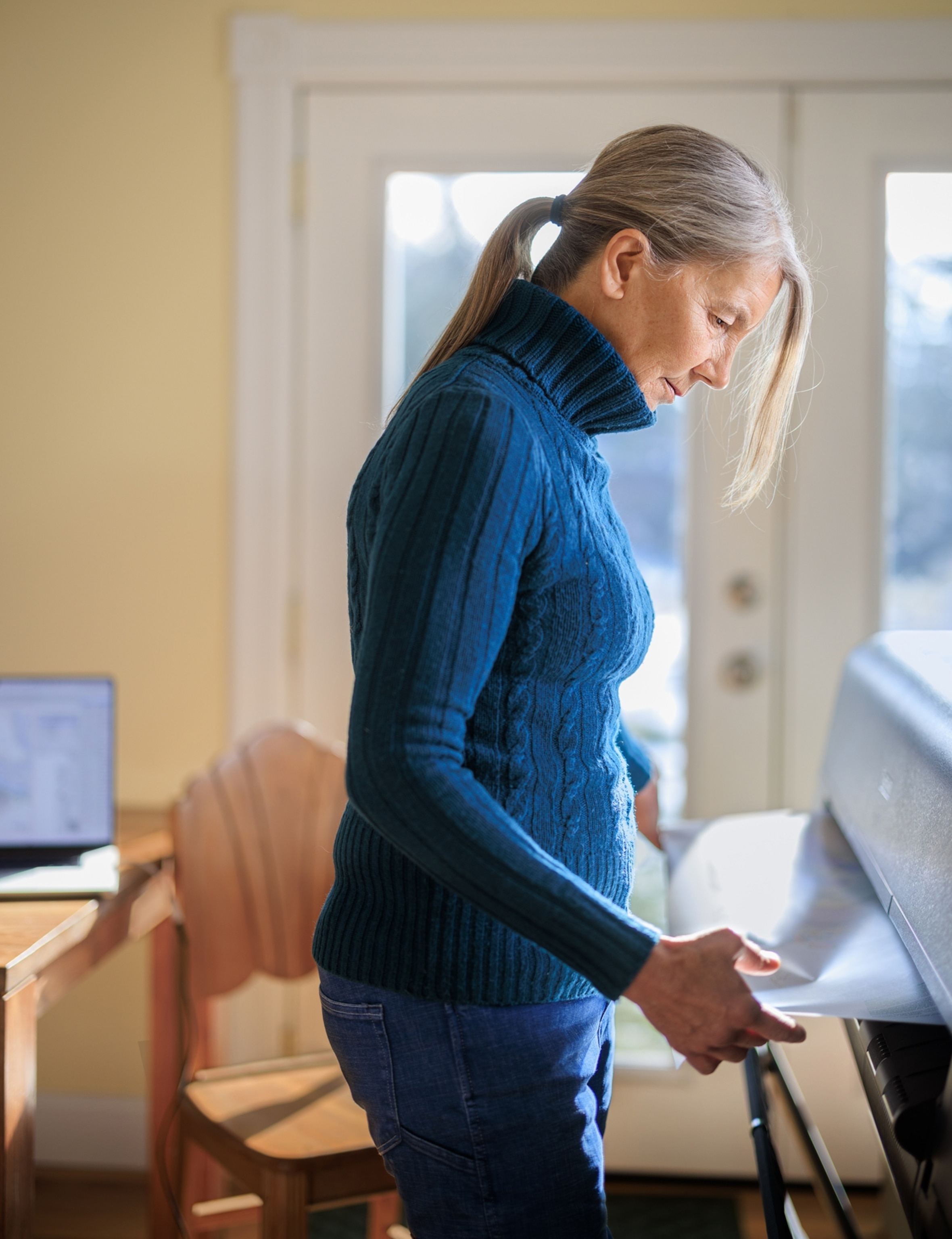 A woman stands and unrolls a map