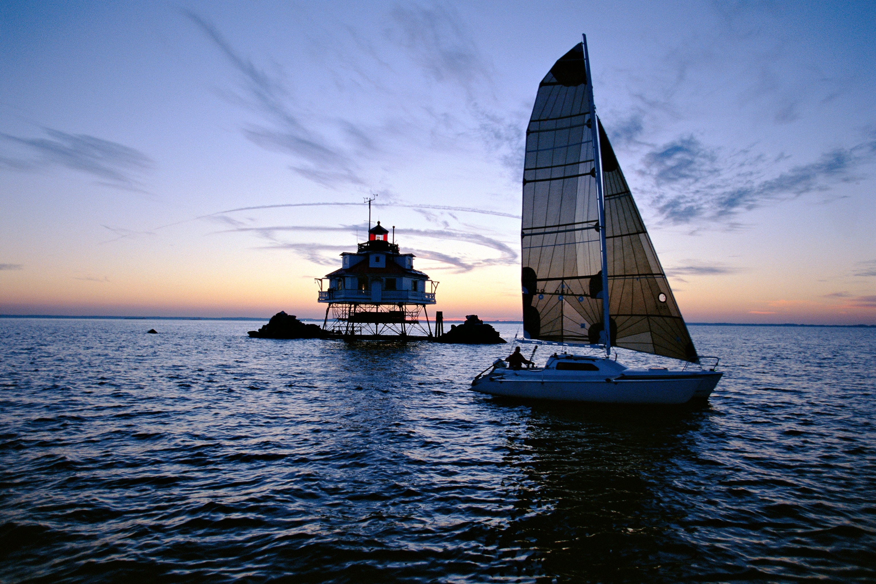 a boat sailing past a lighthouse in Annapolis, Maryland