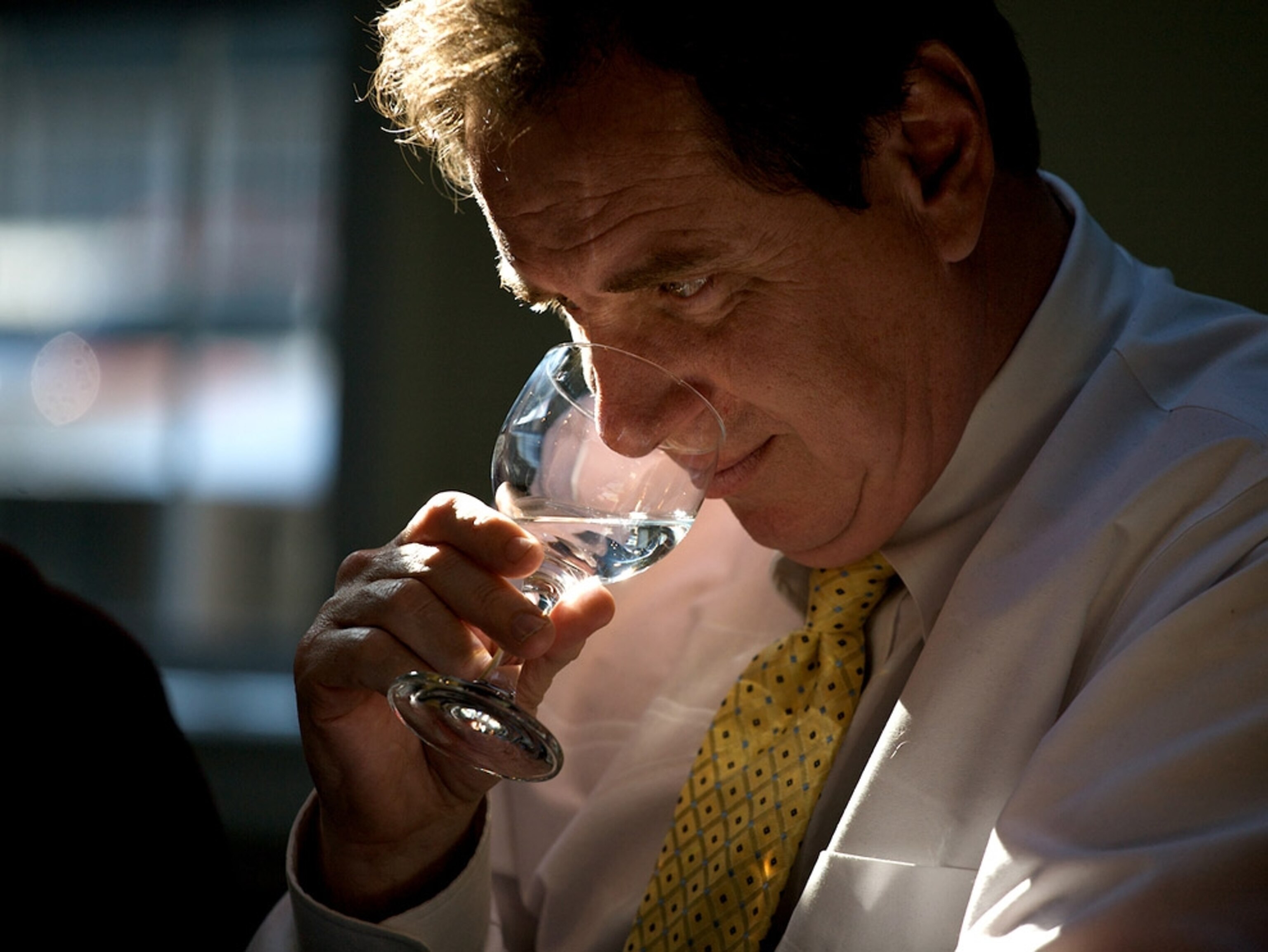 A man sniffs a glass of water