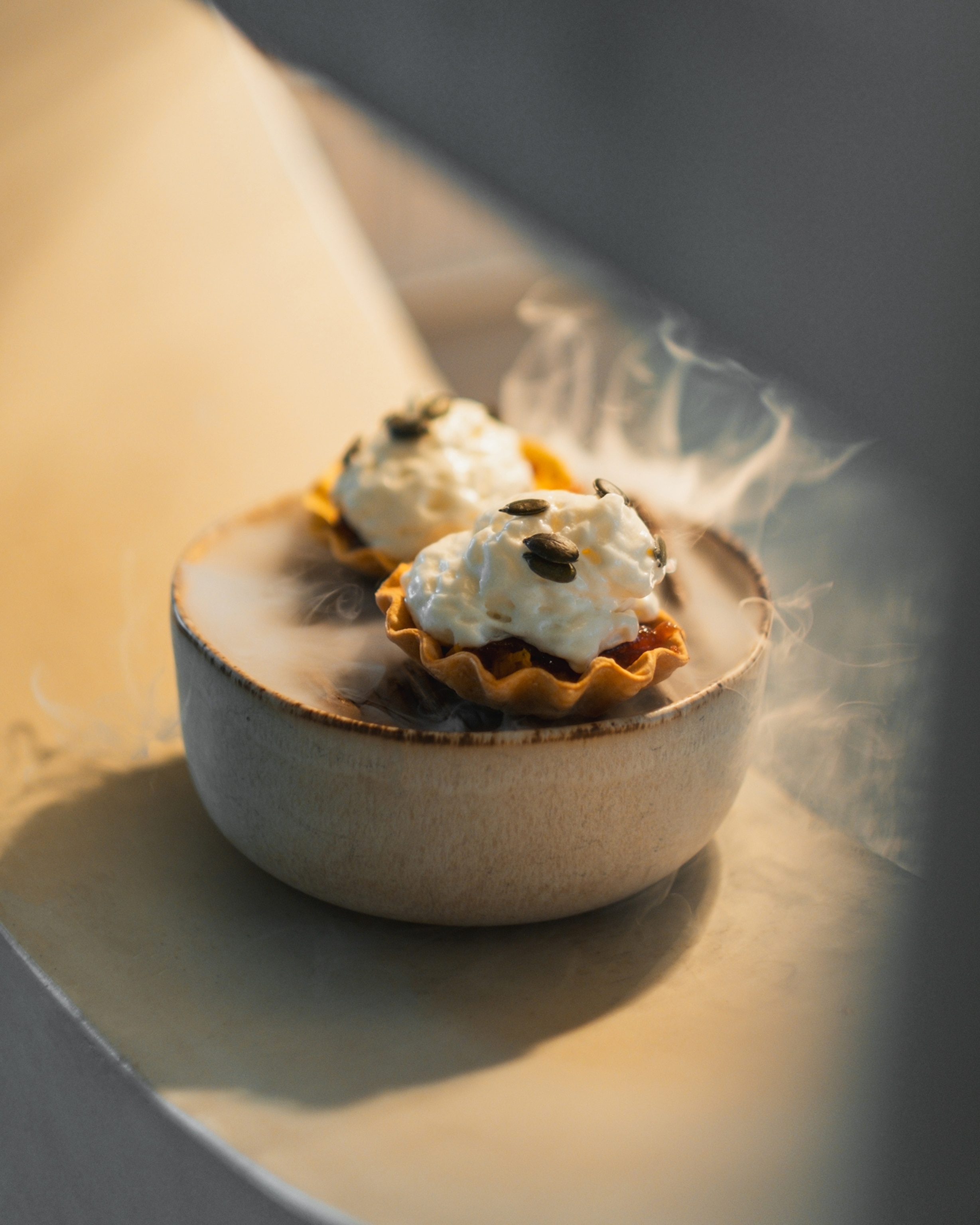 Tartlet with roasted pumpkin, goat cheese foam and pumpkin seeds on the pass.
