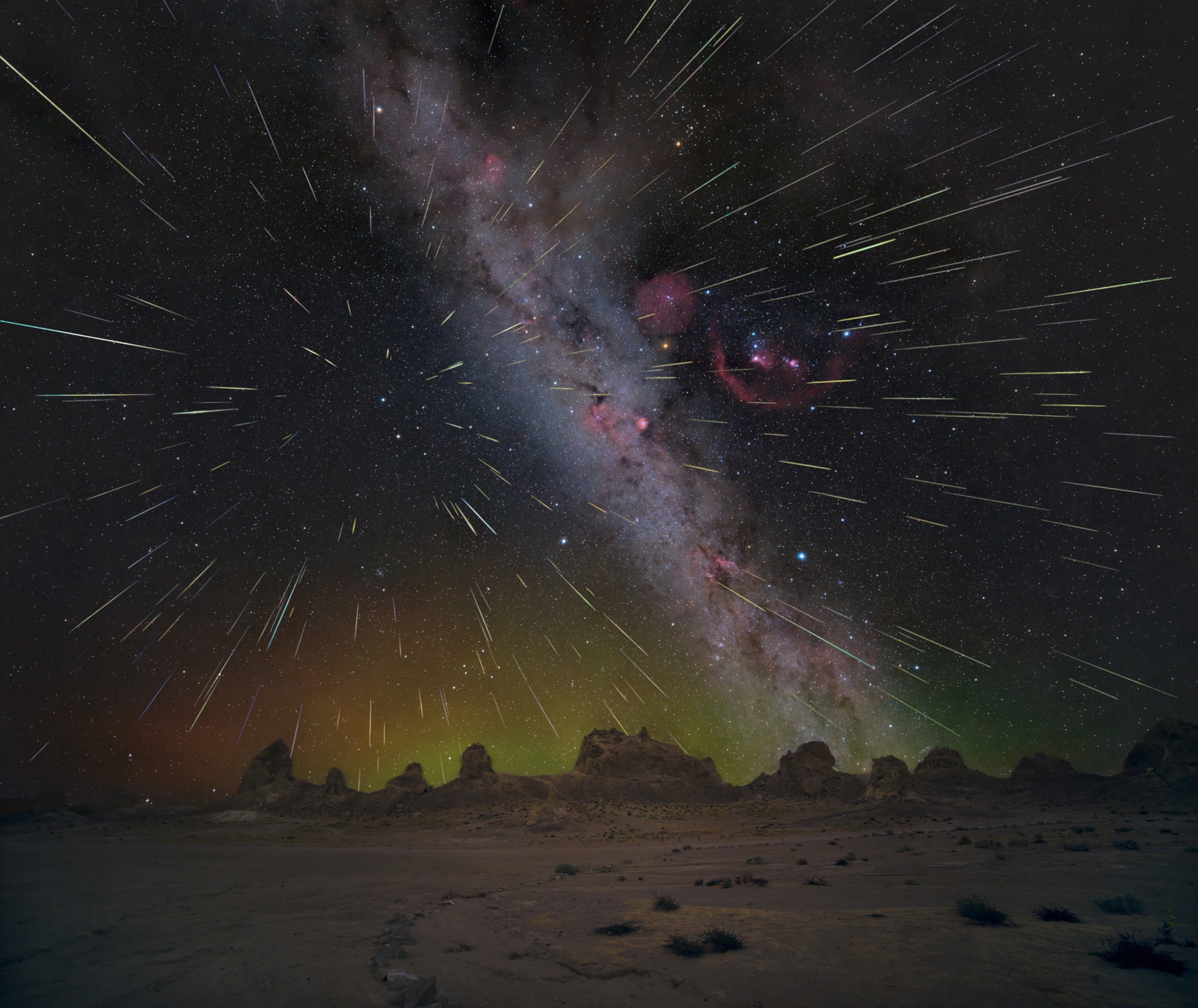 Hundreds of meteors streaking through the night sky above rocky formations in the desert