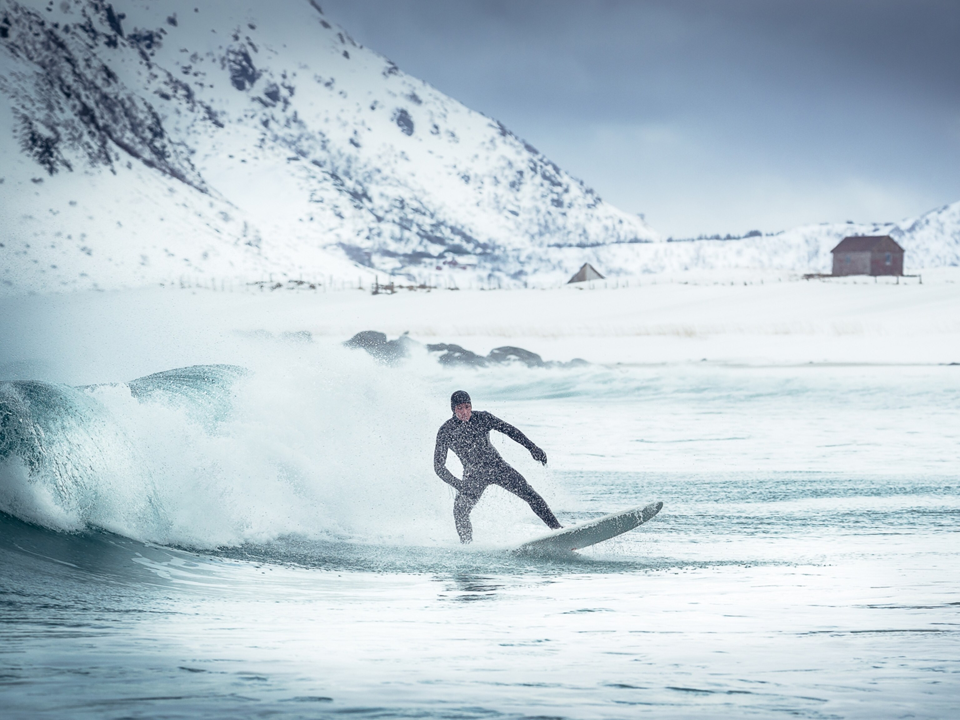 a surfer surfing in the arctic conditions of Norway