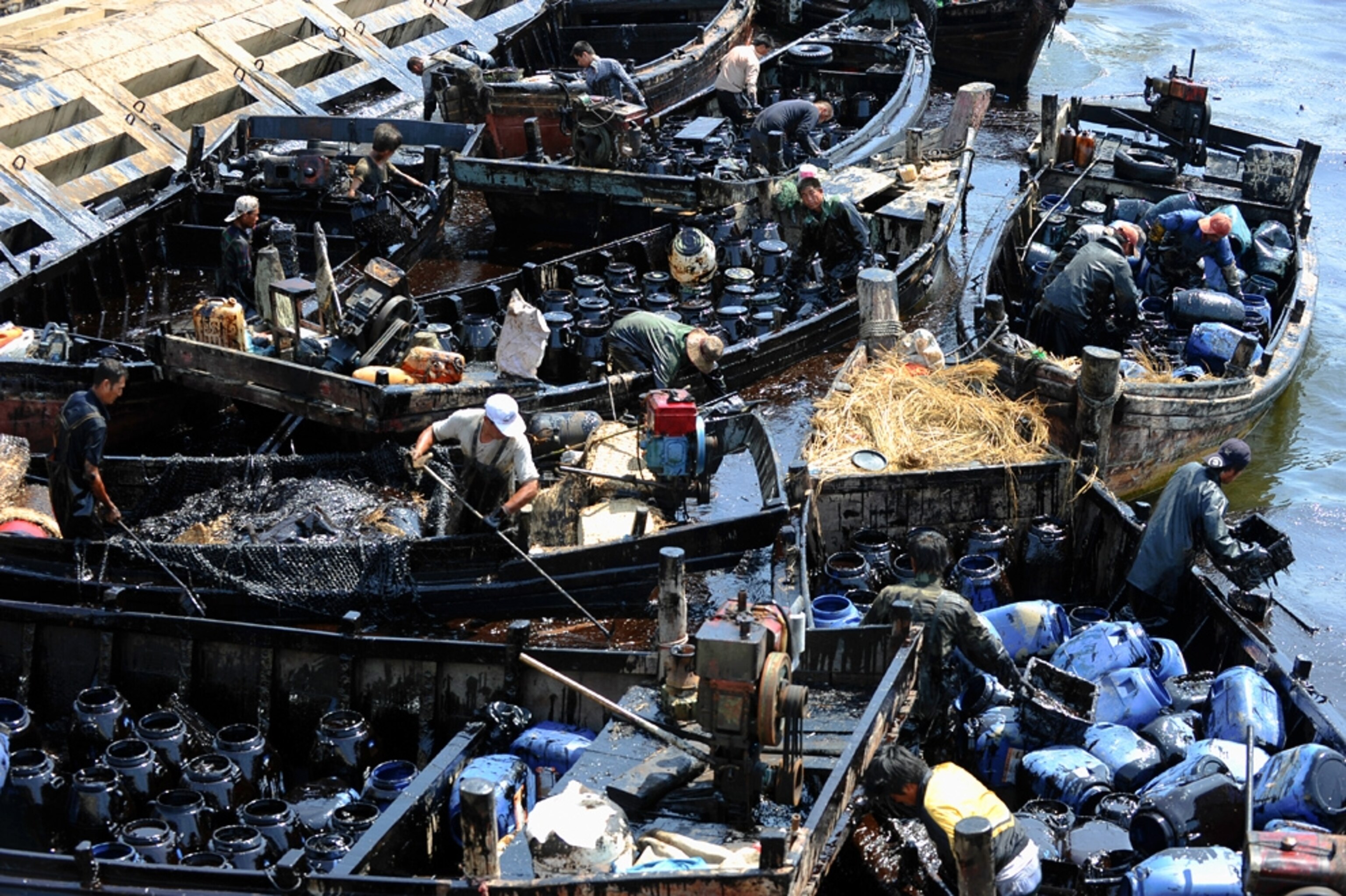 Picture of cleanup workers tending to the China oil spill near Dalian.