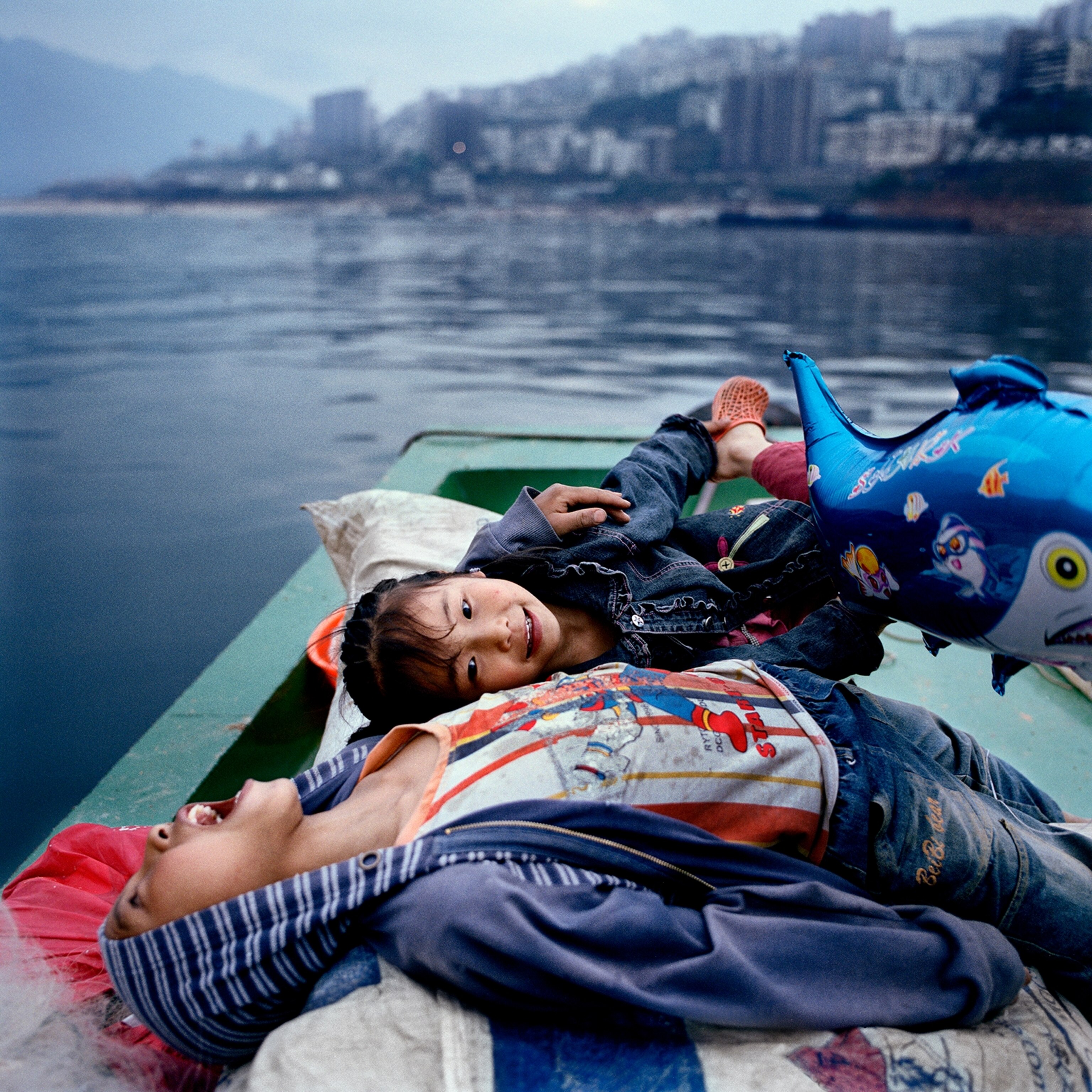 Huang Zongguo’s children play on the family fishing boat near Wushan. Like many rural Chinese, Huang violated the nation’s planned-birth policy and paid a fine of $1,500. “We still have the old thinking,” he says. “Two are better than one.”