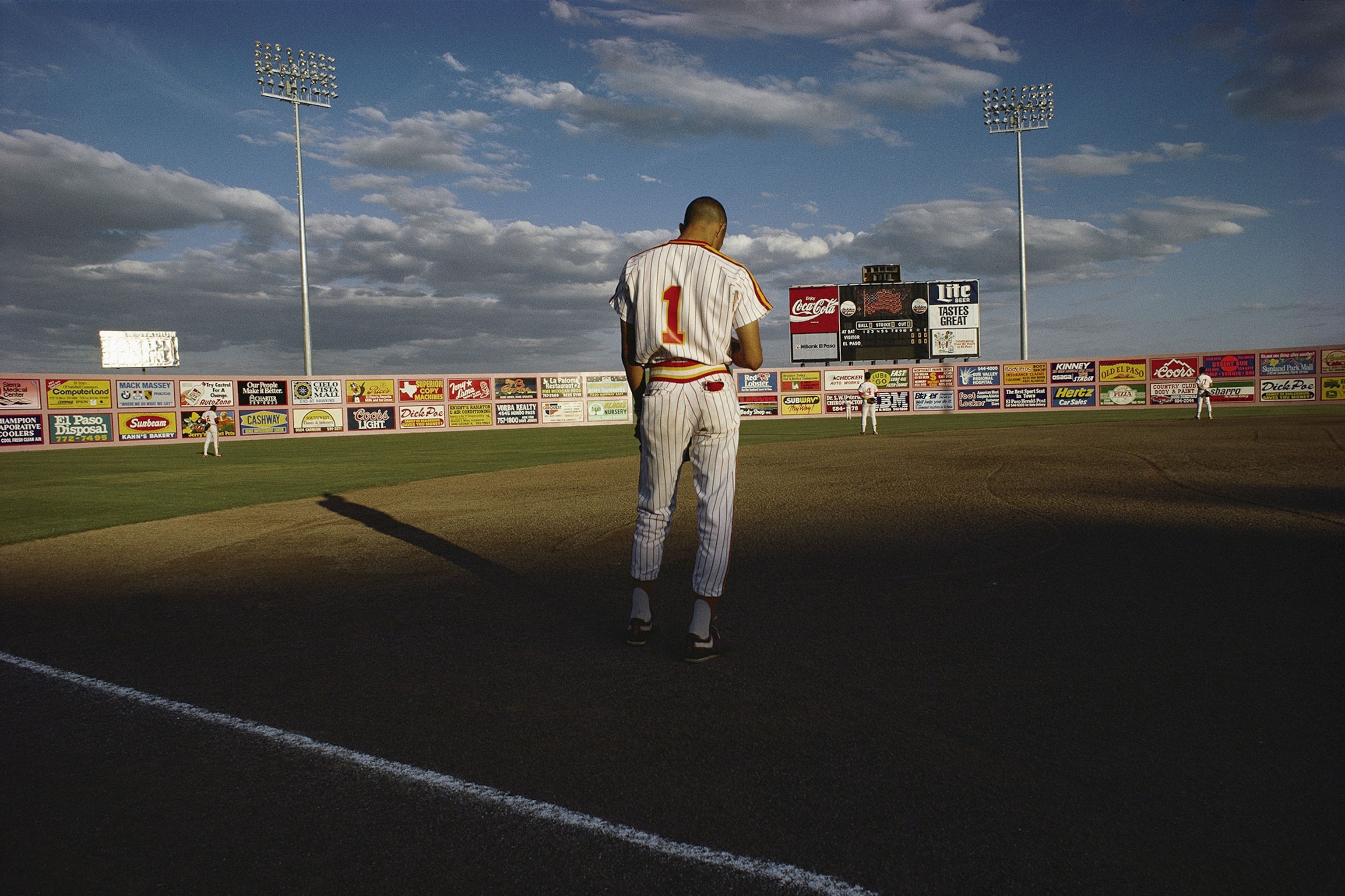 a baseball player bowing his head during the American National Anthem