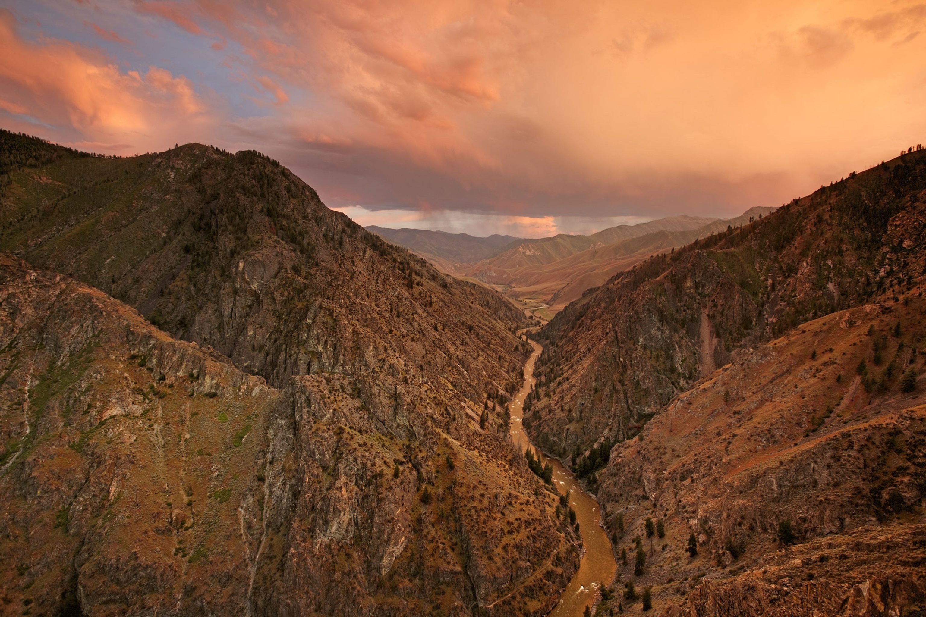 Landscape image of the Middle Fork of the Salmon River from a high perspective, under a glowing pink sky