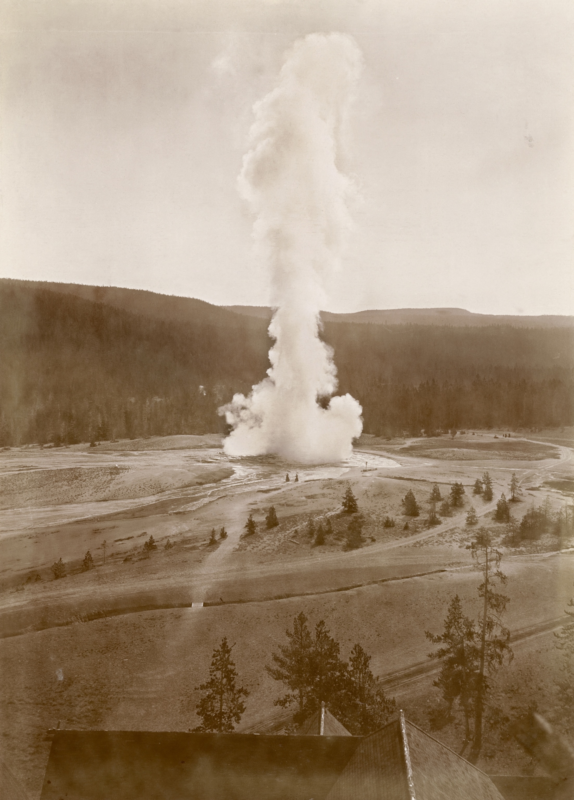 Archival photo showing two women walking near Yellowstone's Old Faithful geyser in 1919
