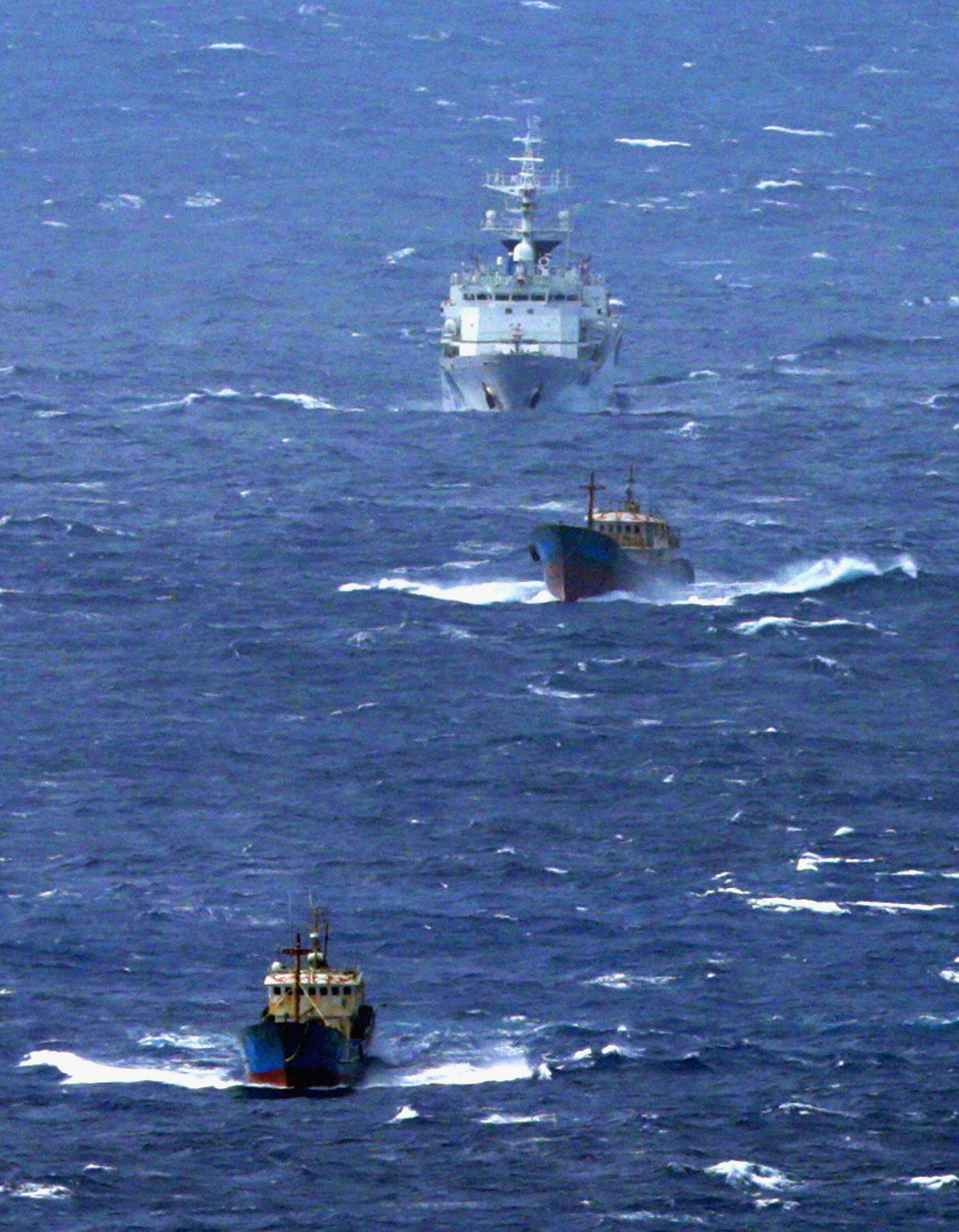 Japan Coast Guard surveillance vessel (top) chases suspected Chinese poaching boats