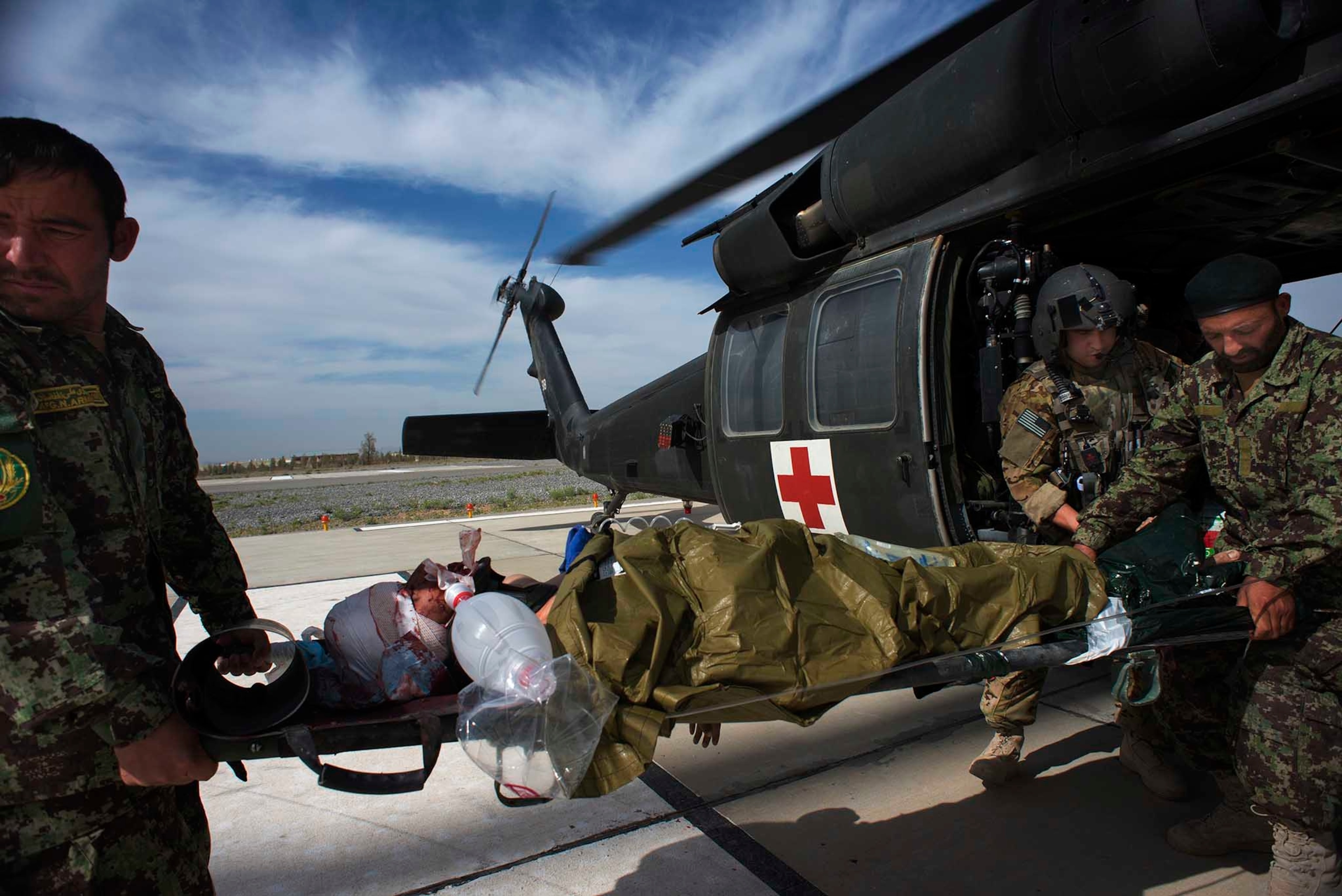 Afghan Air Force Medics, Azizullah Mosawi, left and Ali Nawaz, right, carry Pvt. Sayed Nooruddin who was shot during fighting, to a waiting ambulance on April 29, 2013 in Kandahar, Afghanistan.