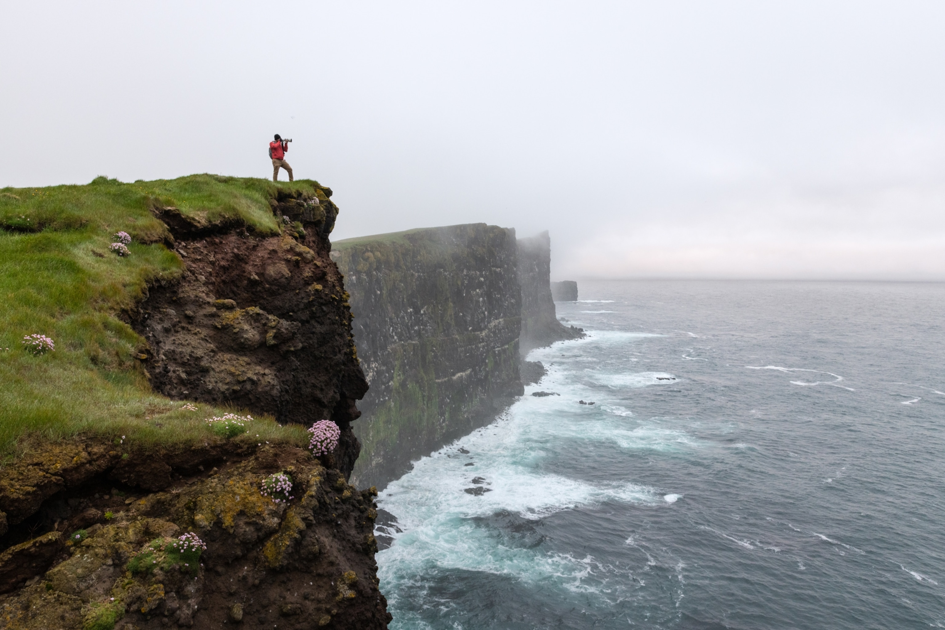 Photographer capturing images on the cliffs of Latrabjarg in the Westfjords