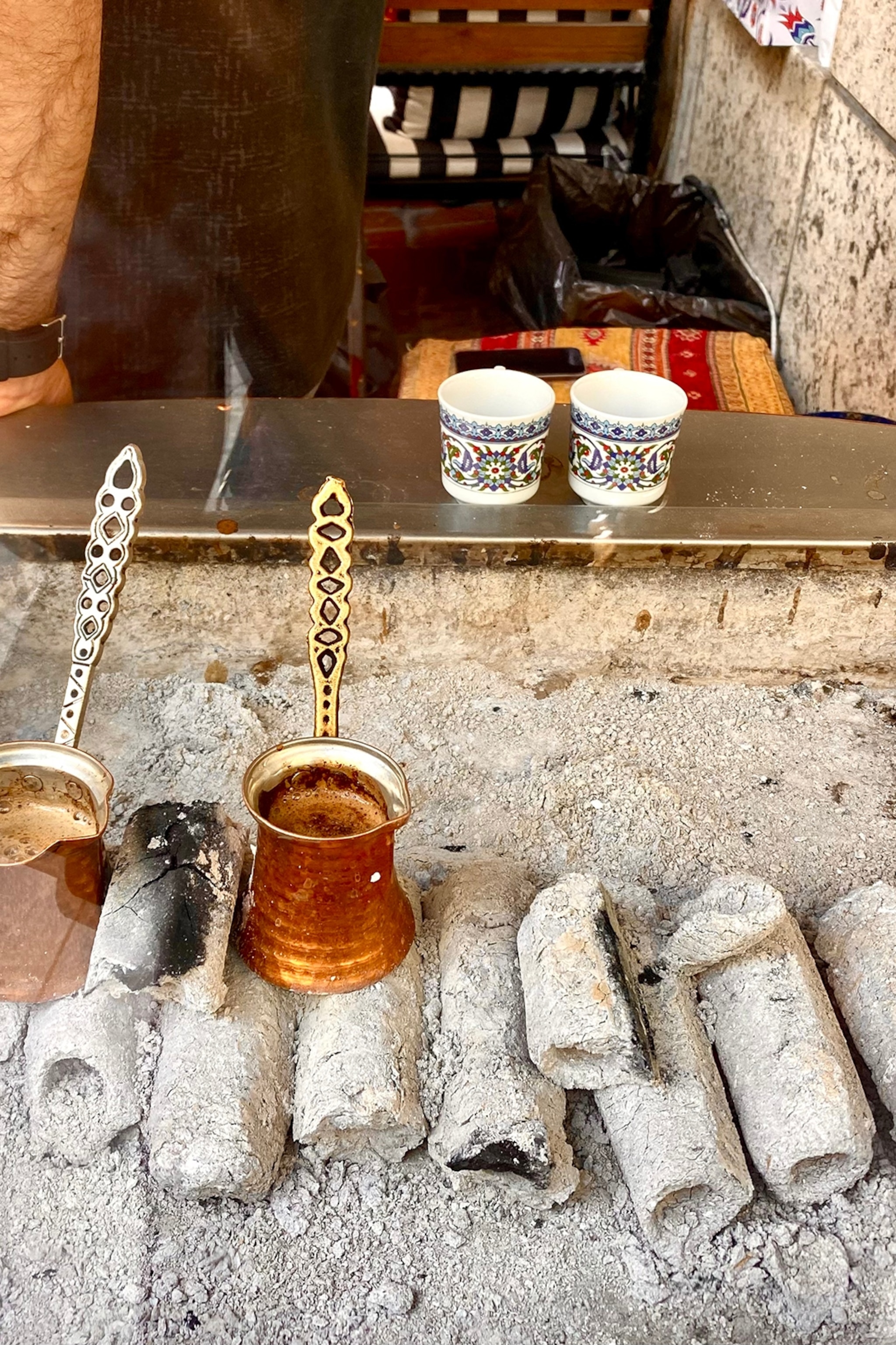 Traditional Turkish coffee pots resting on hot coal in Istanbul.