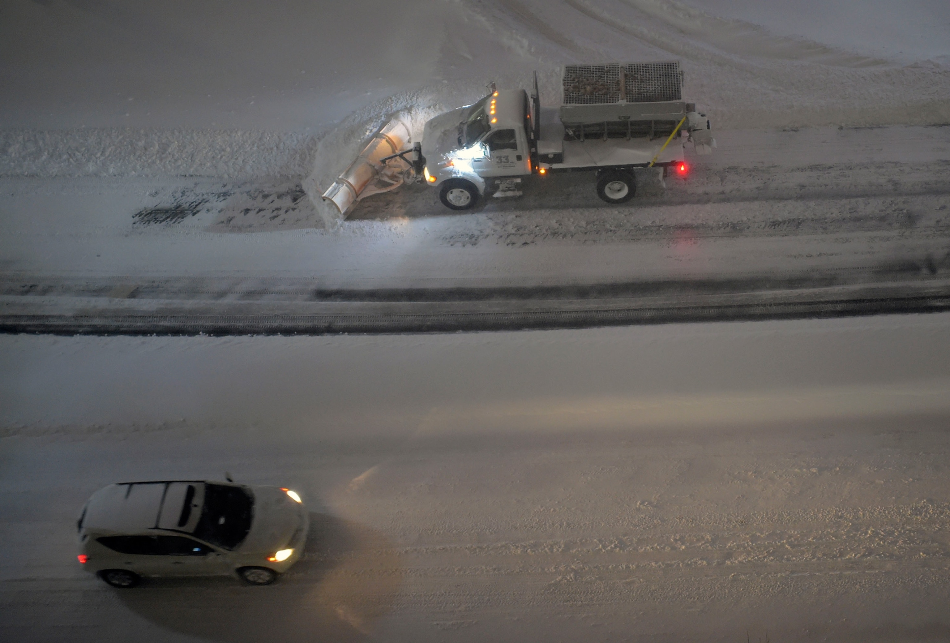 a car passing a snow ploy on the road in Arlington, Virginia