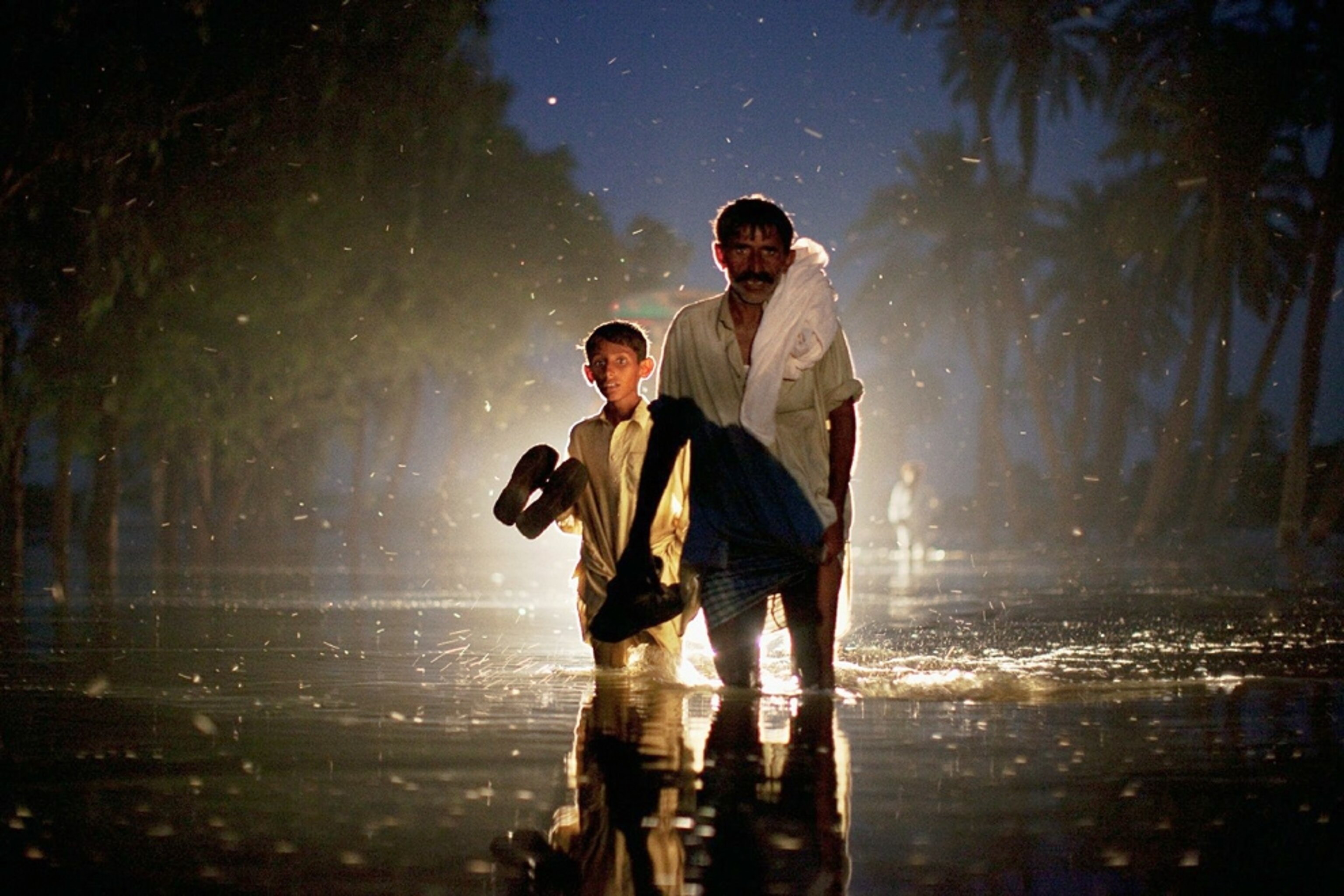 a Pakistani man and boy leaving their village during the Pakistani floods