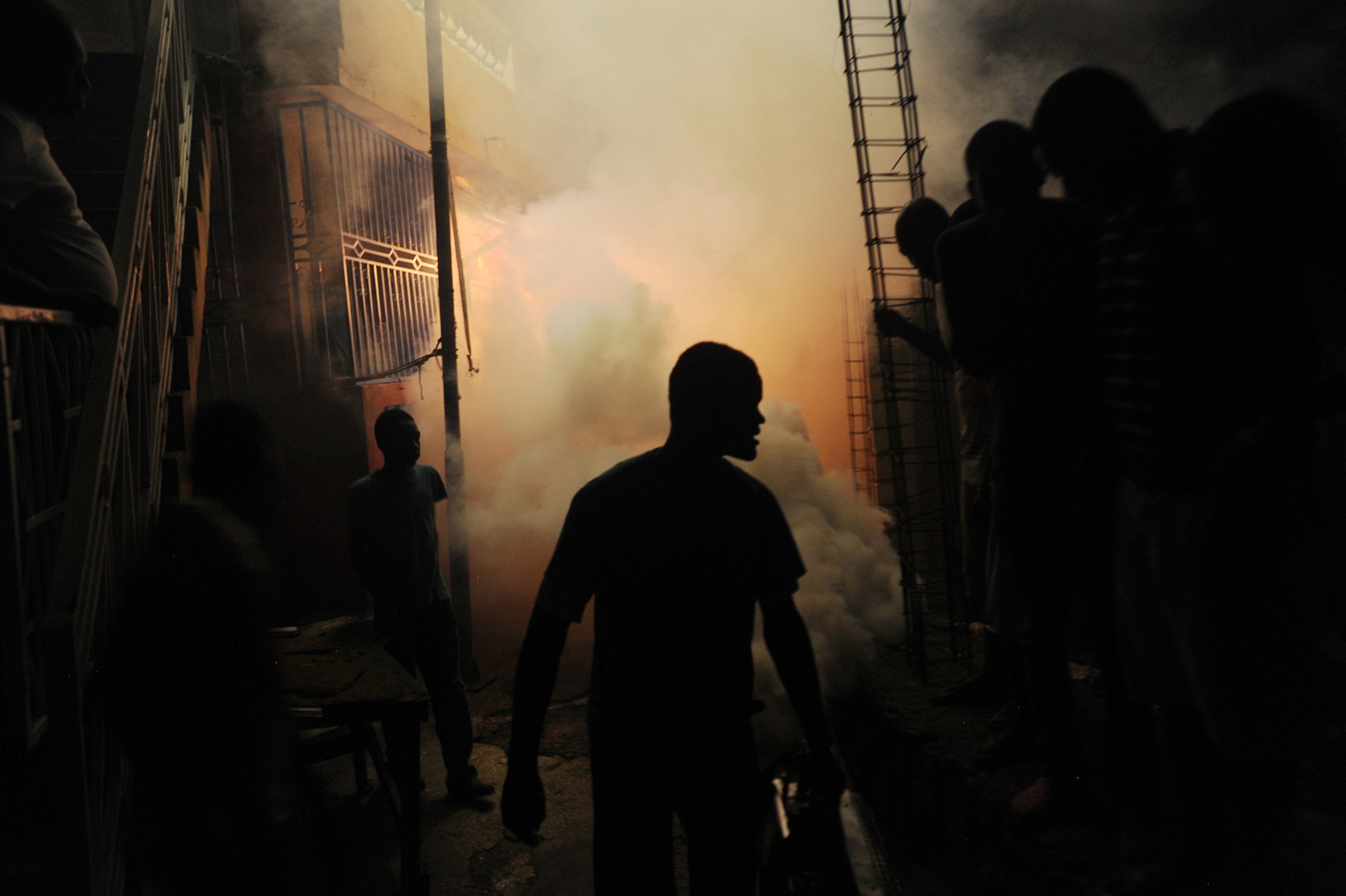 Workers from Haiti's Ministry of Public Health and Population spray chemicals to exterminate mosquitoes in a neighborhood of Petion Ville in Port-au-Prince on May 21, 2014.