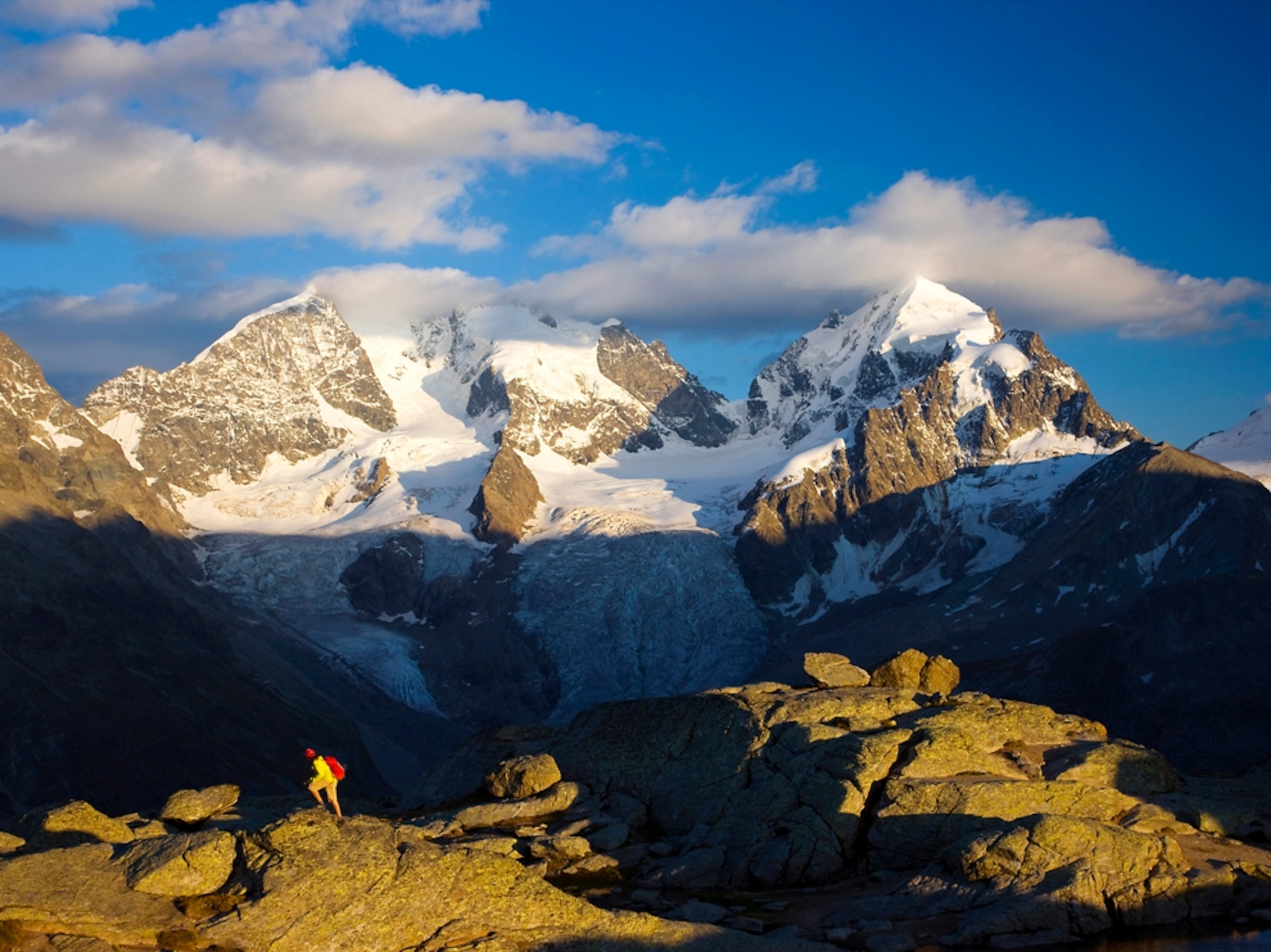 man hiking with Swiss Alps in background