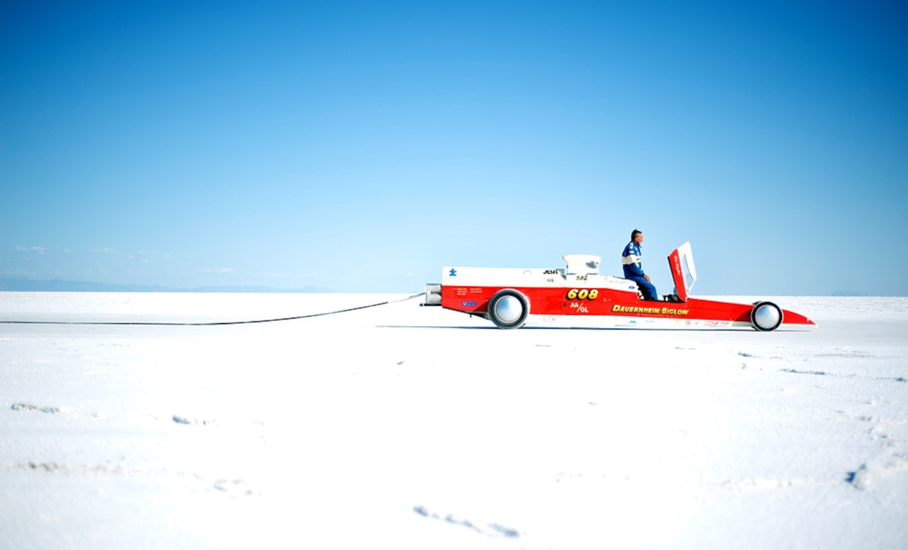 A racer sits in his car on the salt flats