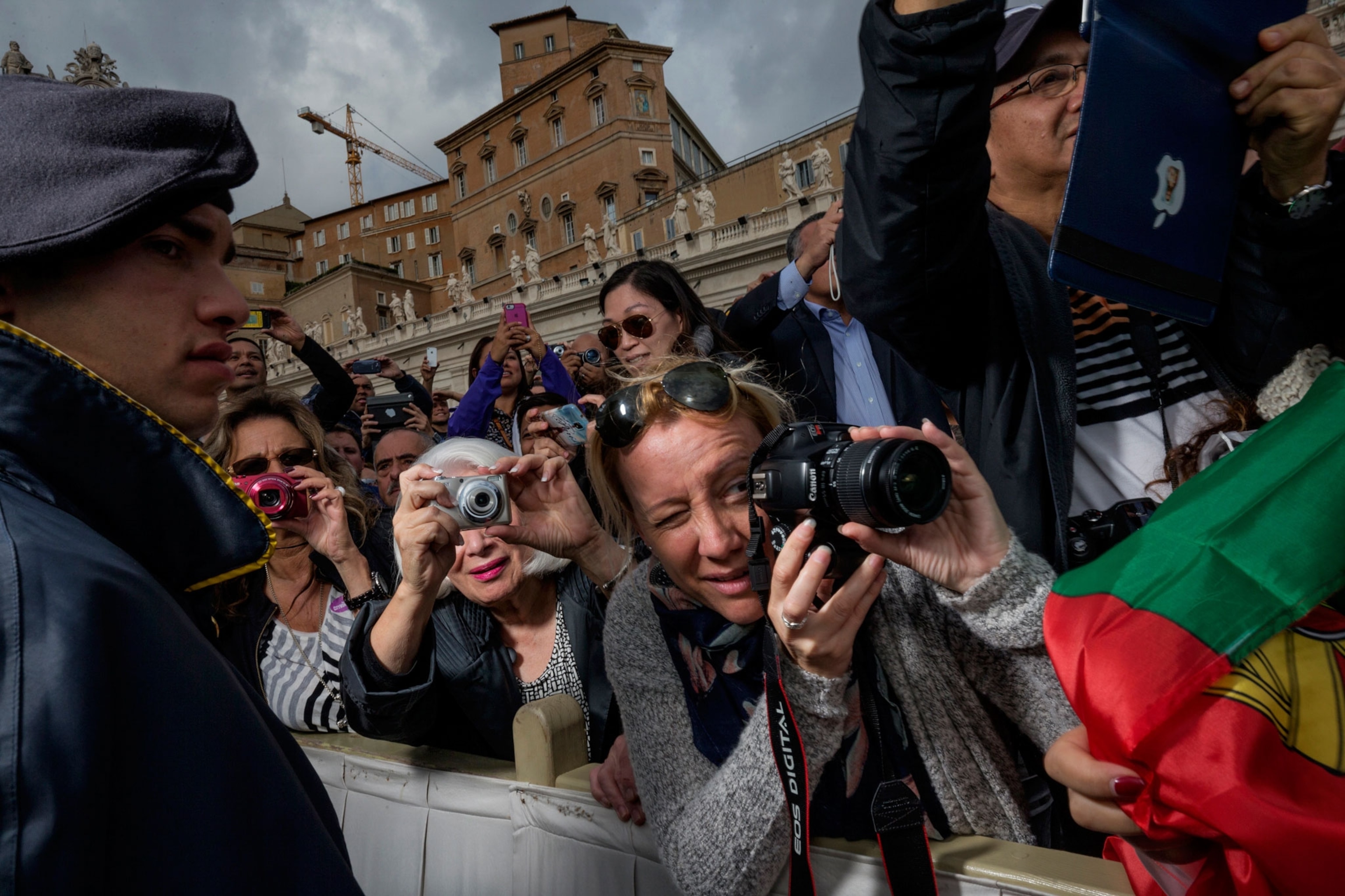 girls taking pictures as they wait for Pope Francis