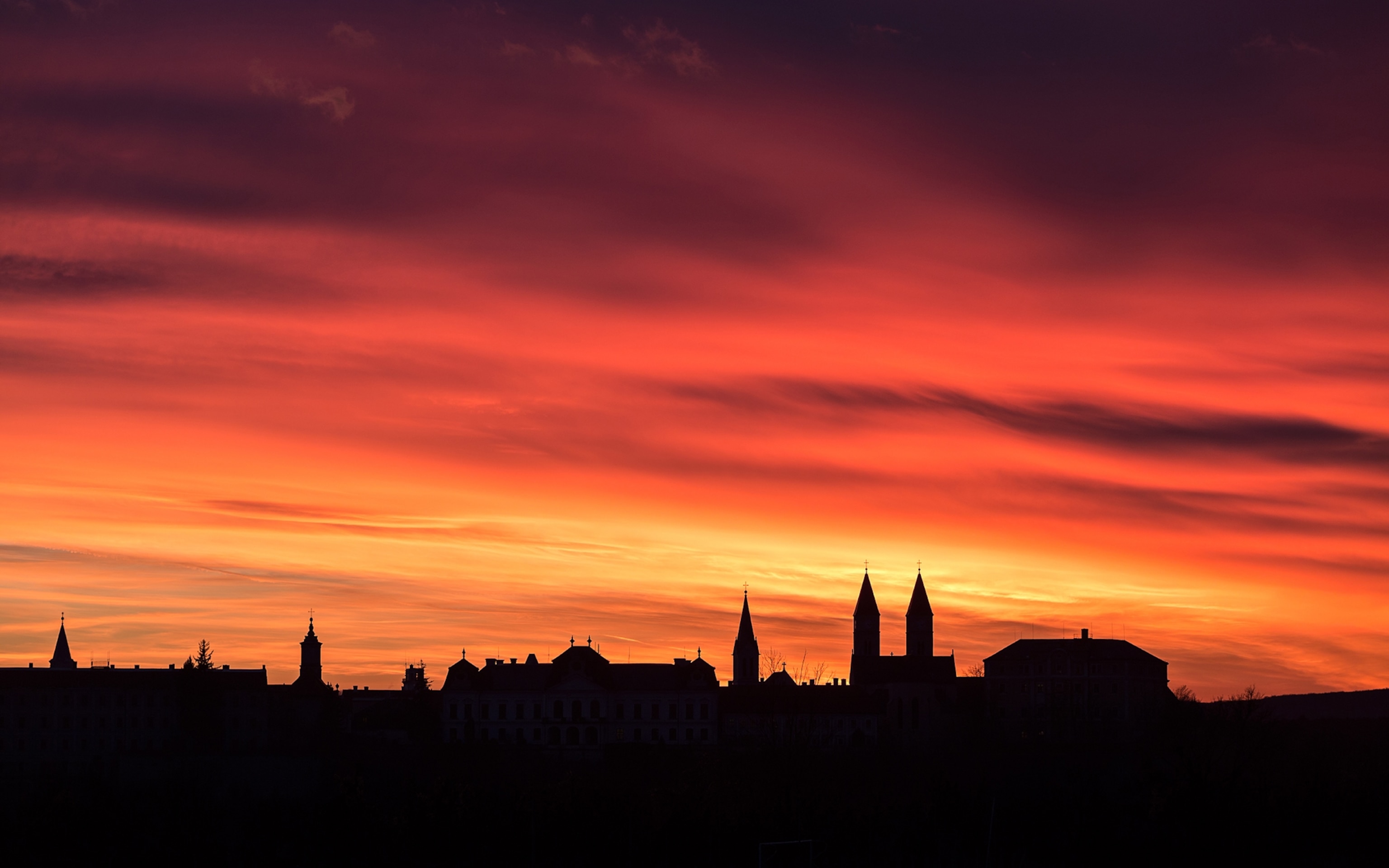 A spectacular sunset at winter solstice over the old town of Veszprém in Hungary. The double tower right below is the silhouette of St. Michael Cathedral.