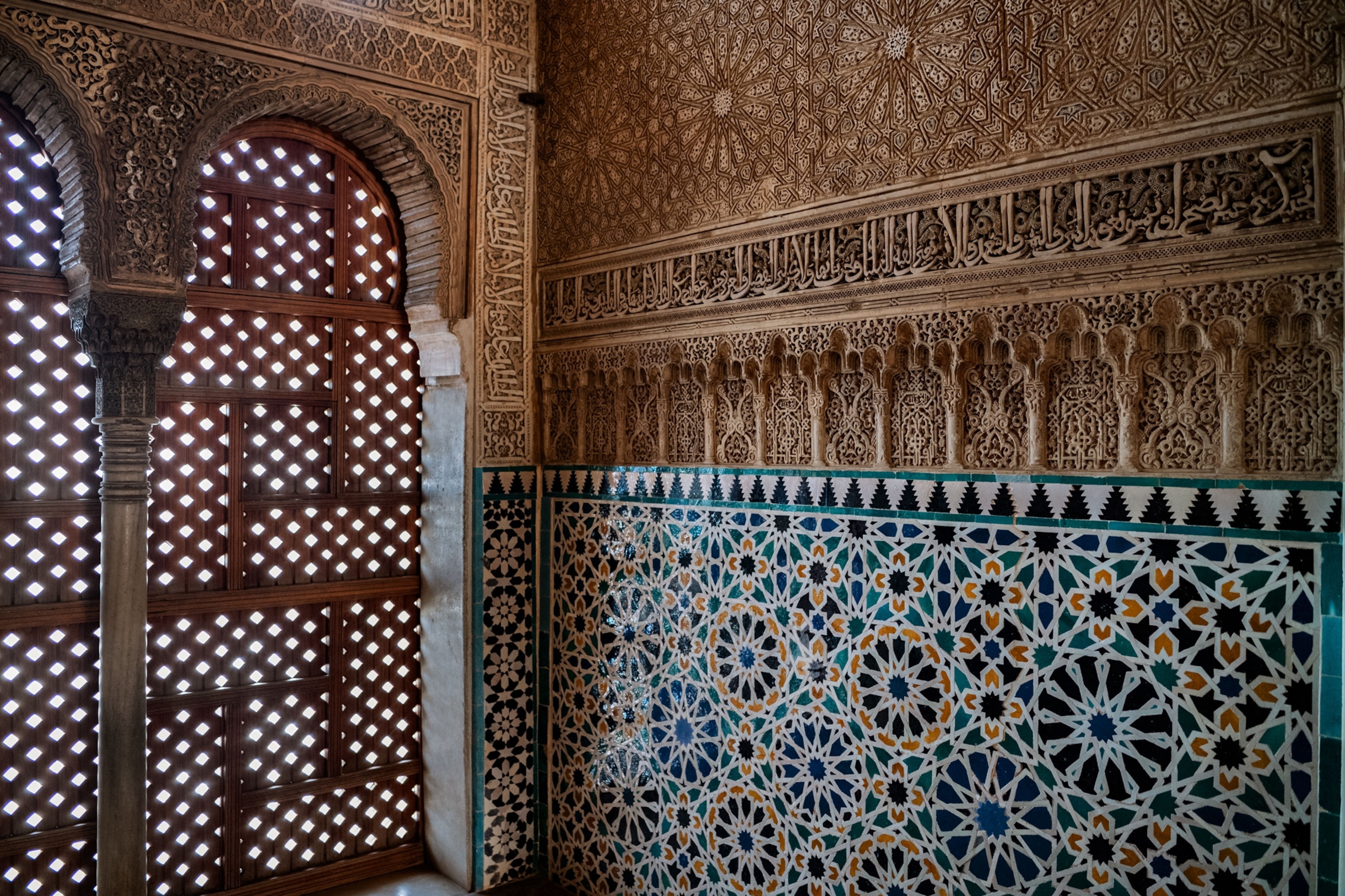 Part of the room wall with tiles and lace like wall covering.