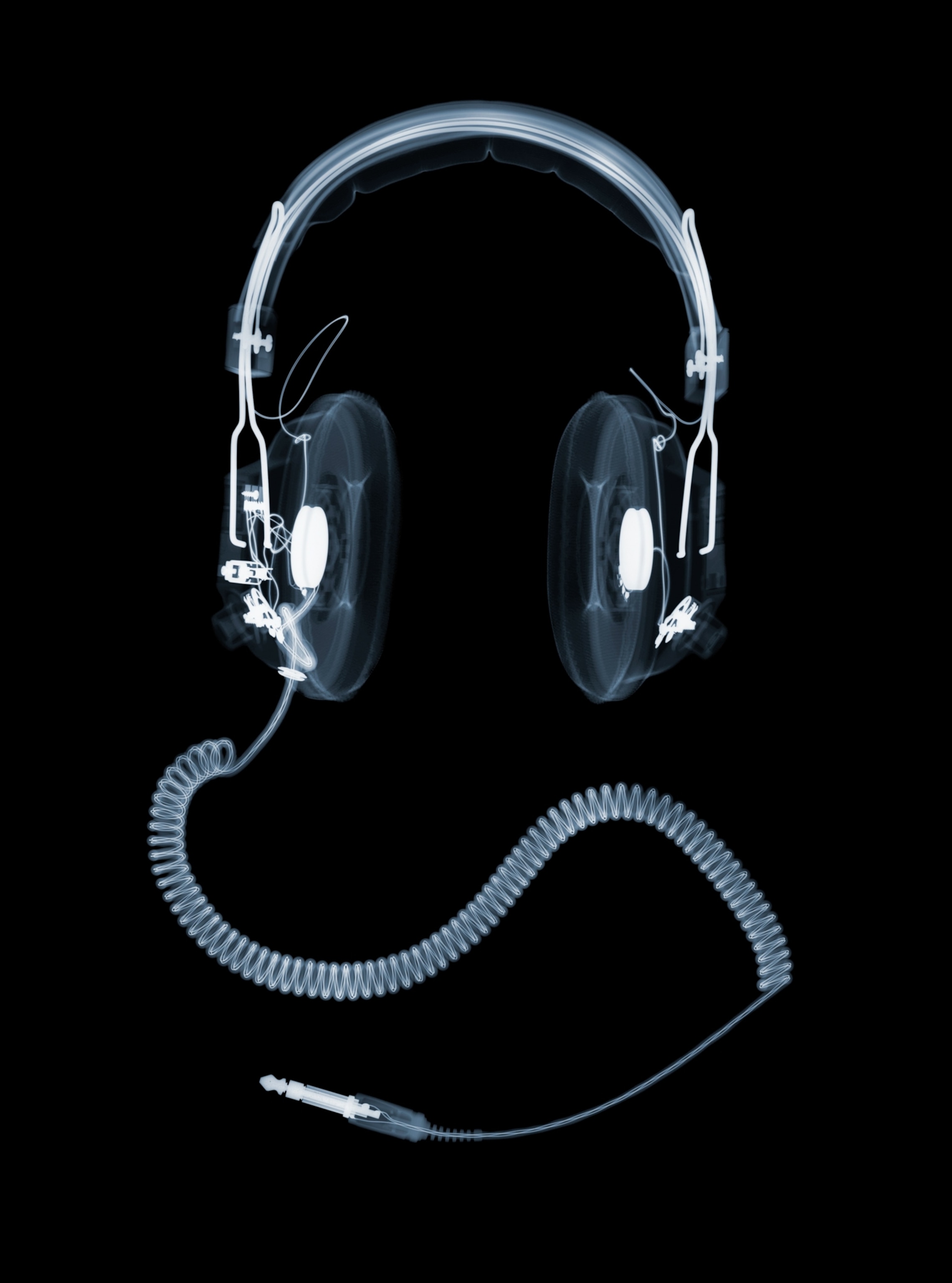 An x-ray view of a pair of over-ear headphones with a coiled cable