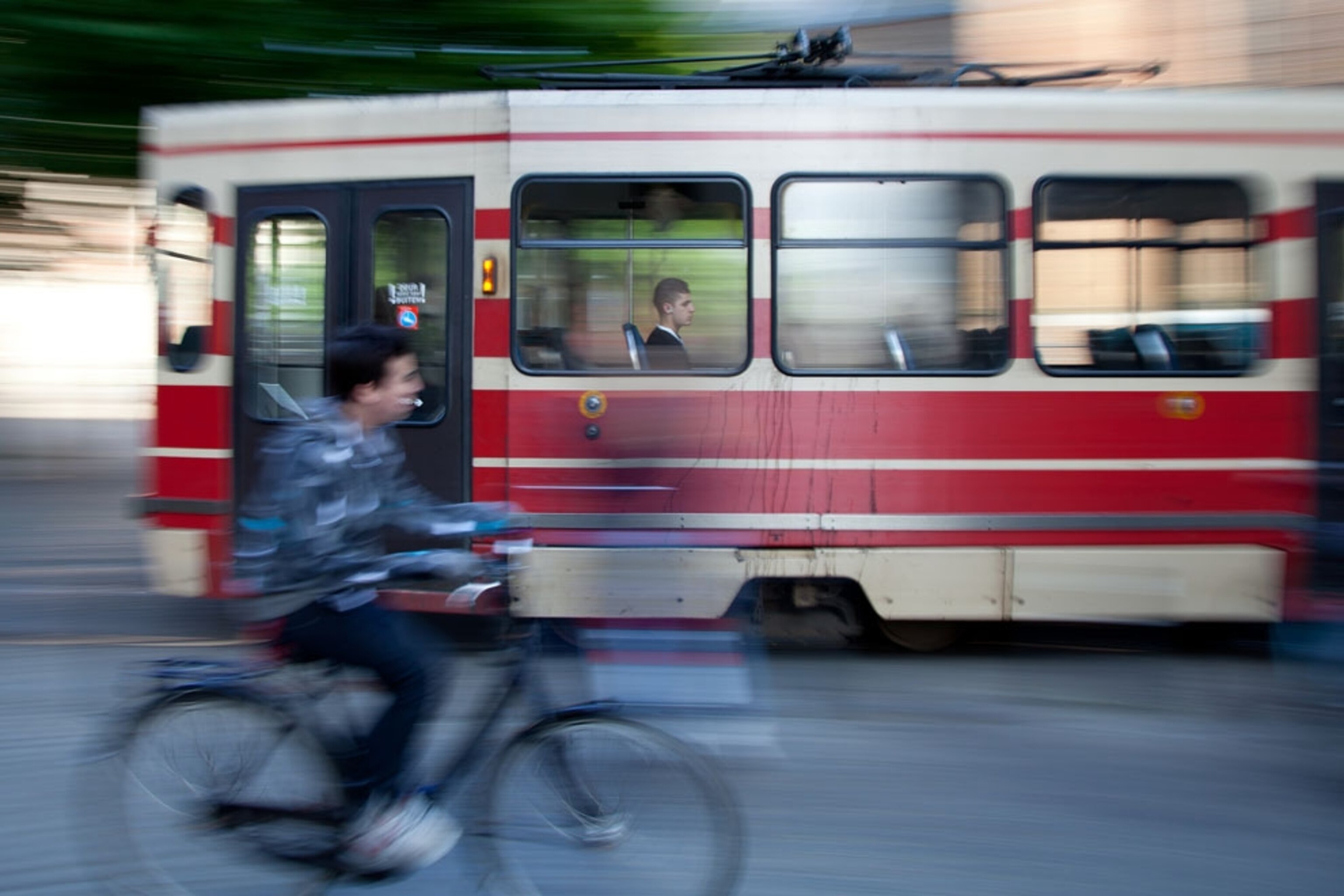 A boy riding a bike near a passing bus in The Hague