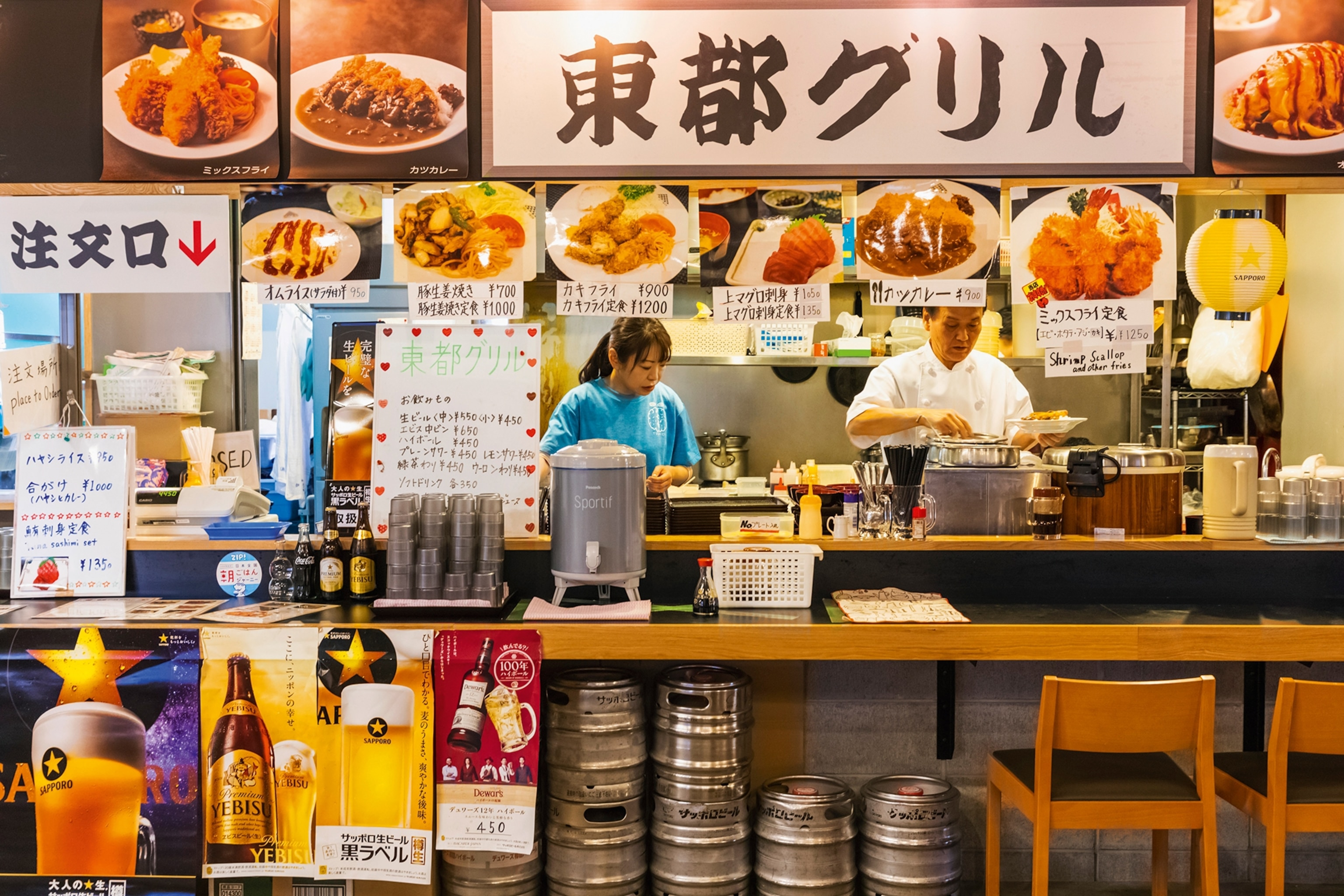 View of the menu and the kitchen behind of a seafood restaurant at Tsukiji Outer Market.