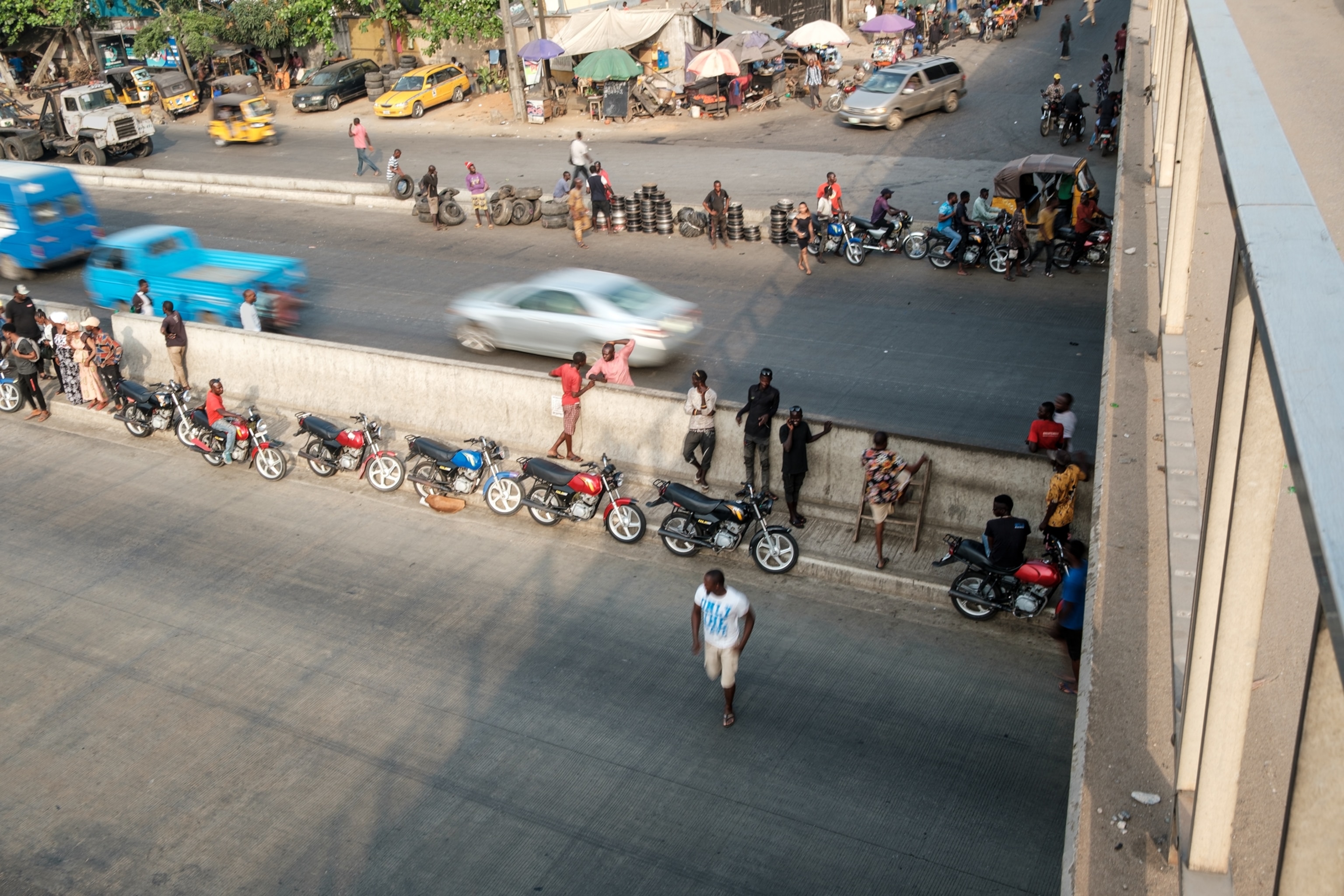 Colorful motorcycles line up along the mid-street dividing barrier.