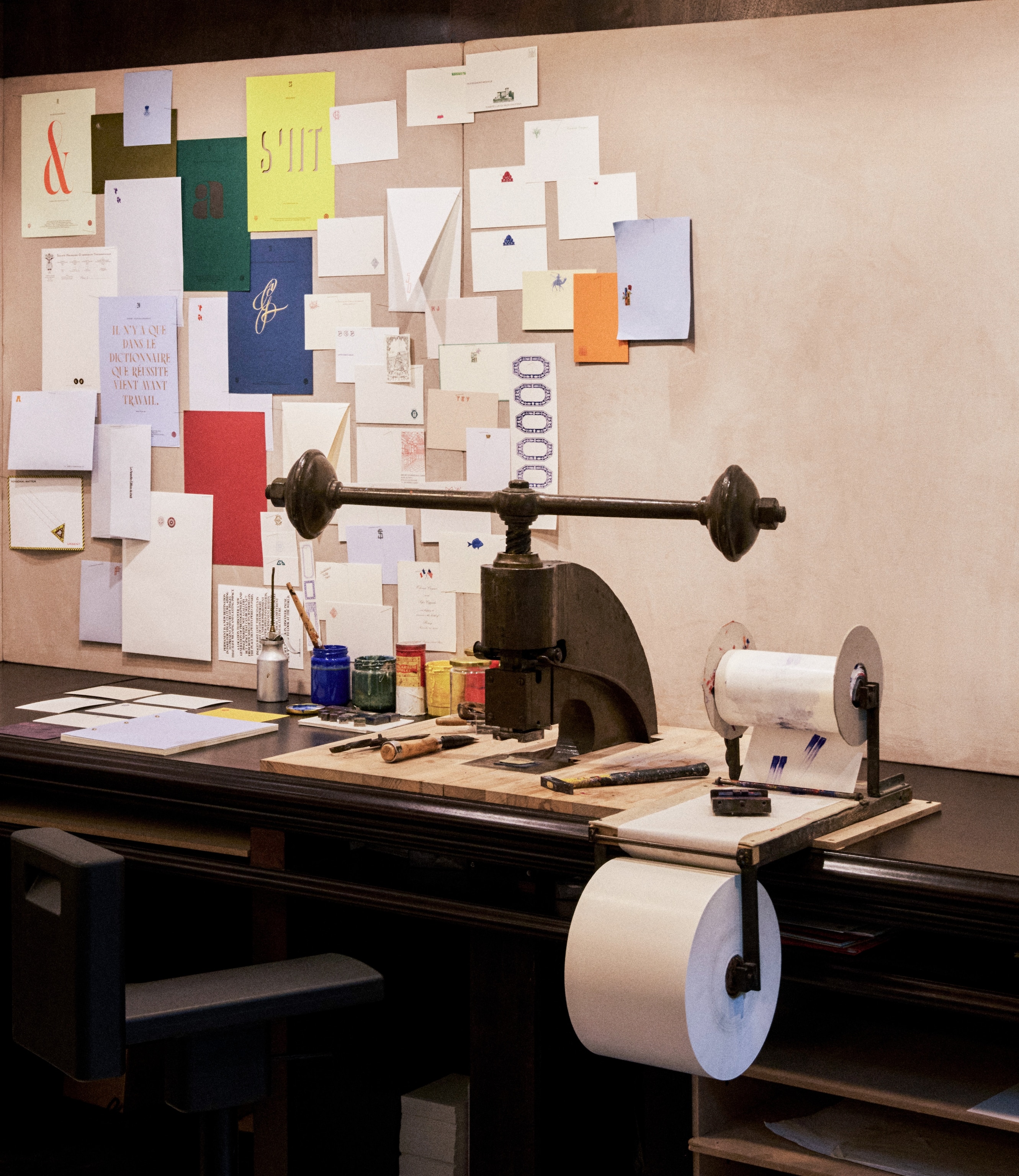 A large printing press with letters in the background