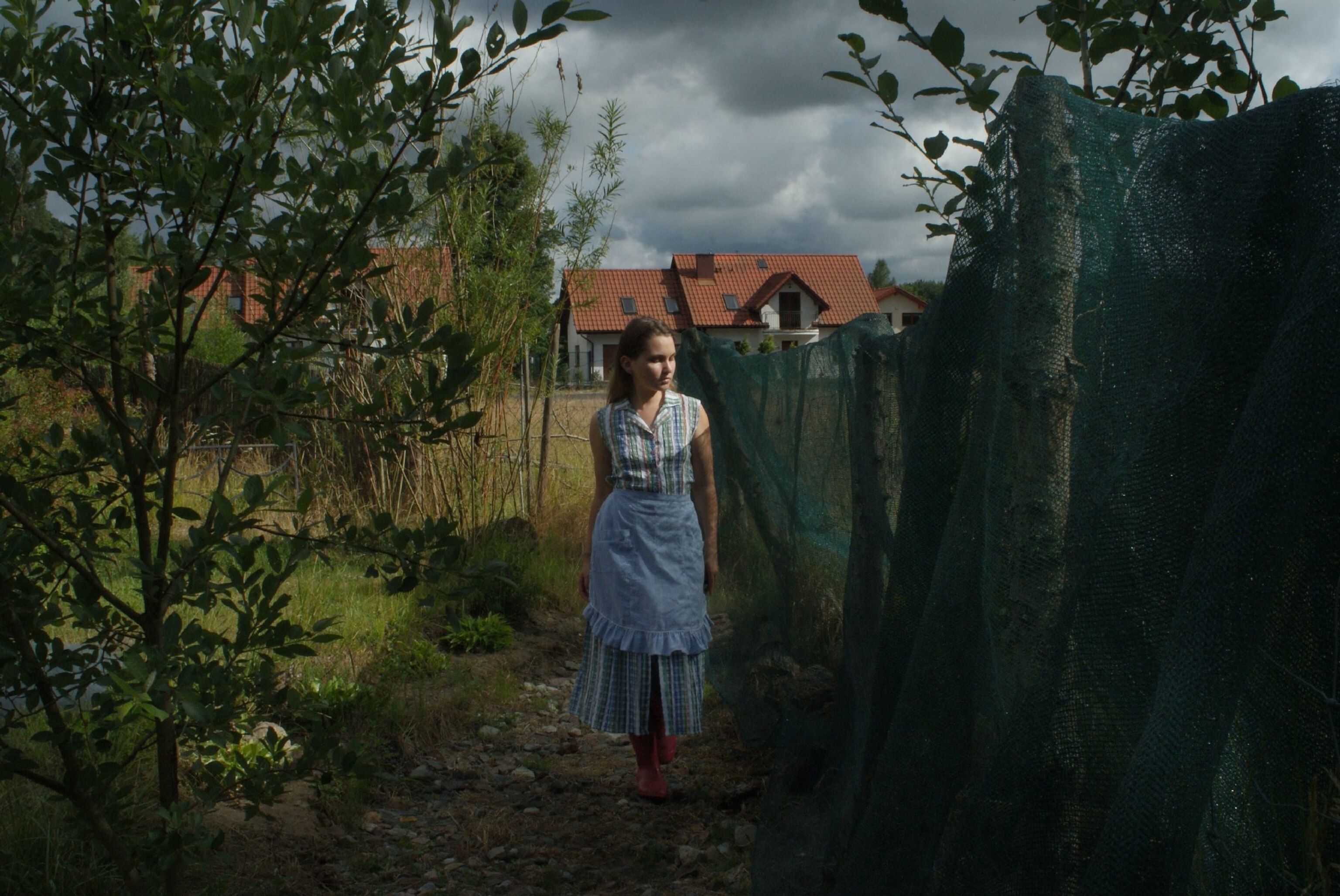 young woman stands in polish countryside for portrait