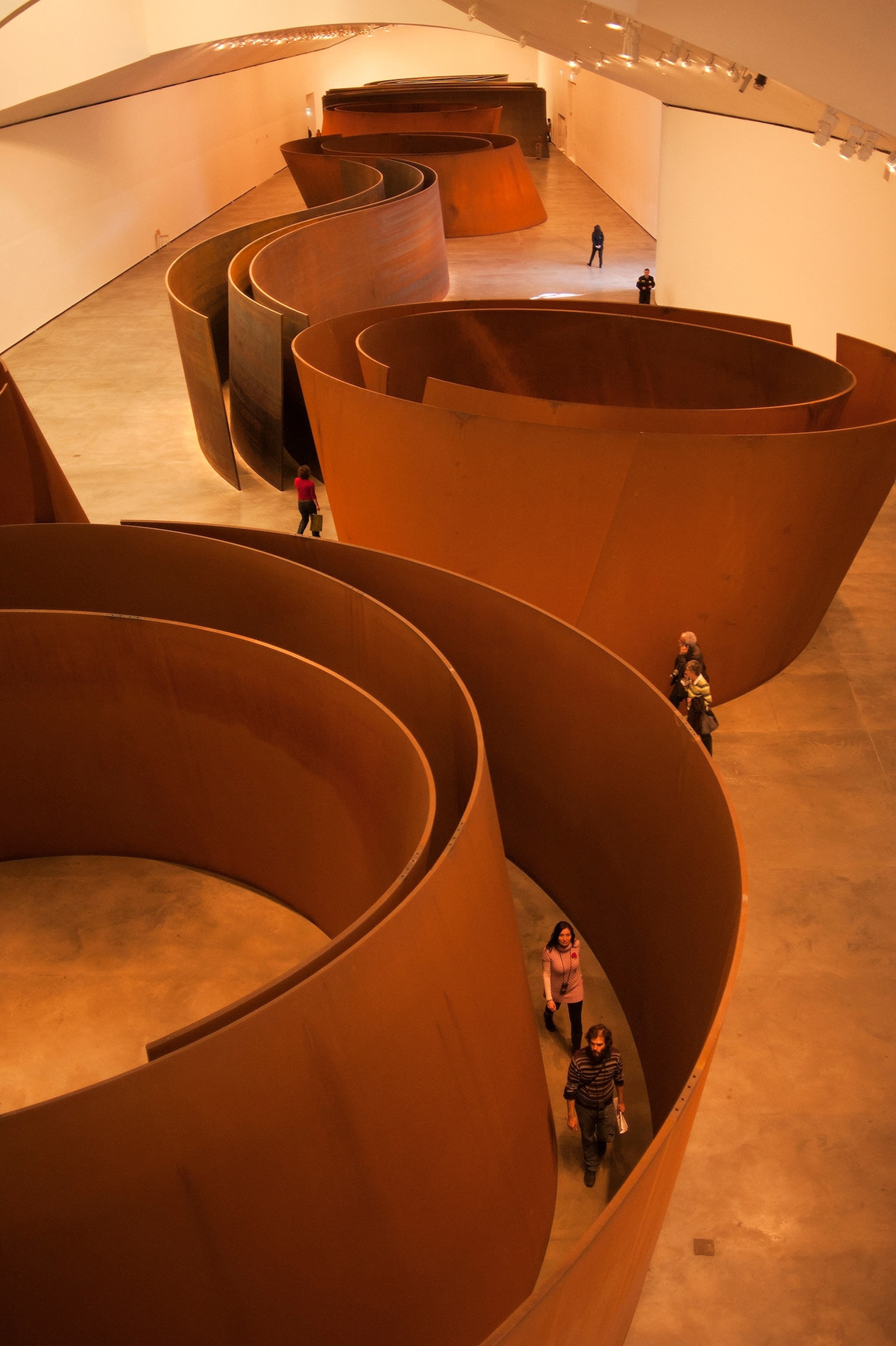 People walk through sculpture by Richard Serra.