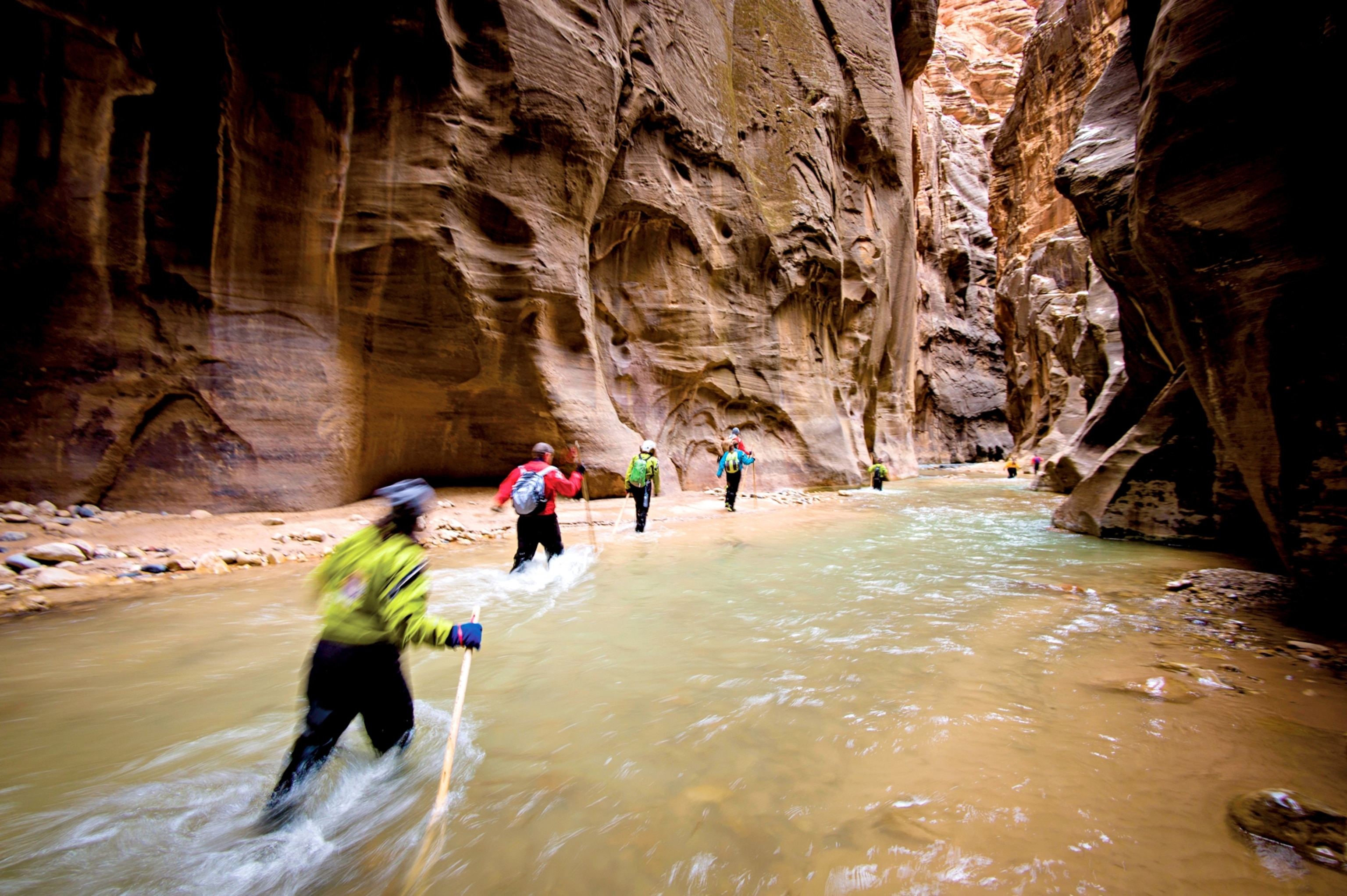 visitors wading the Virgin River in a slot canyon in Zion National Park Utah