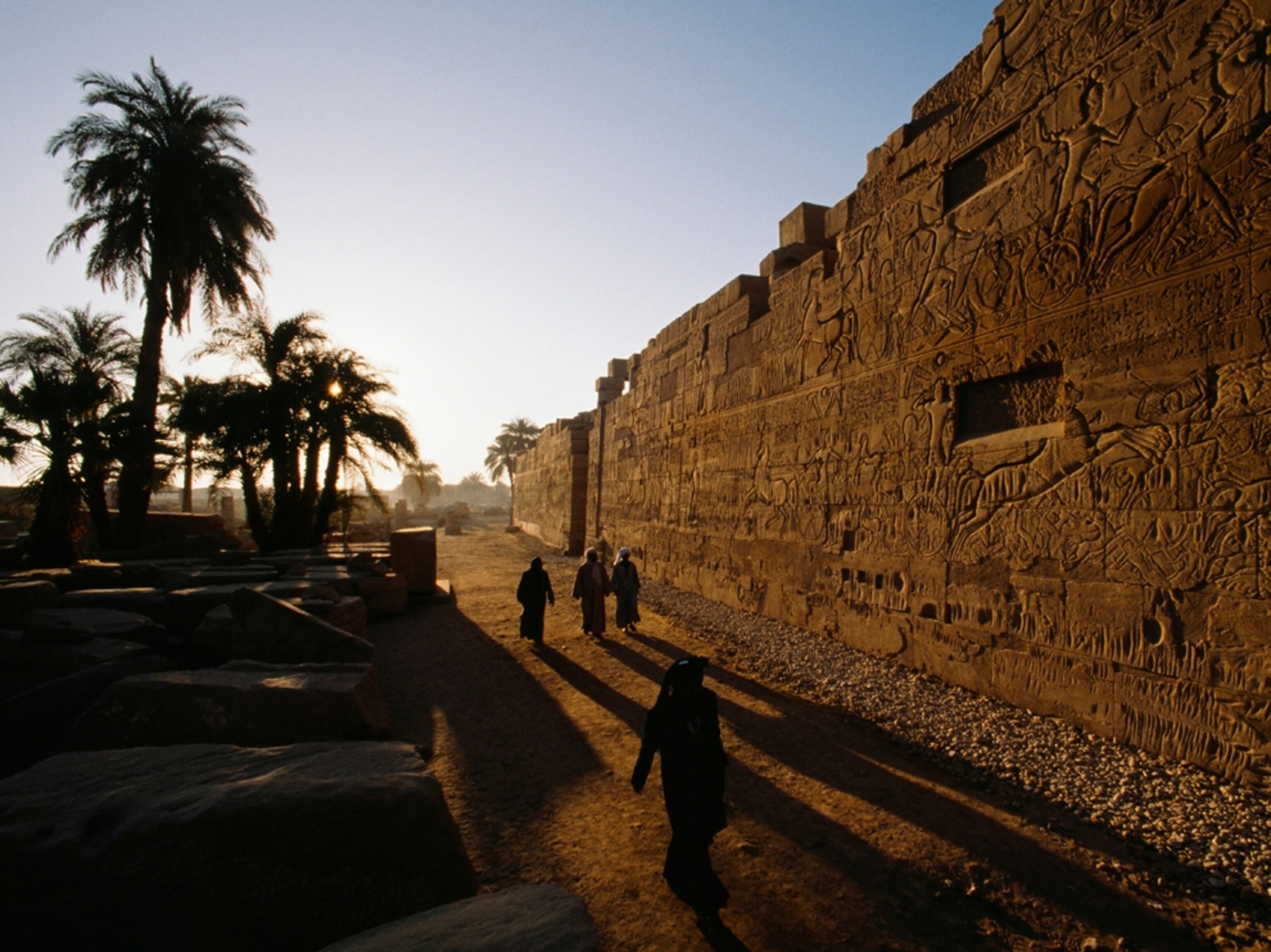 Men walk past inscriptions at Karnak Temple, Luxor, Egypt