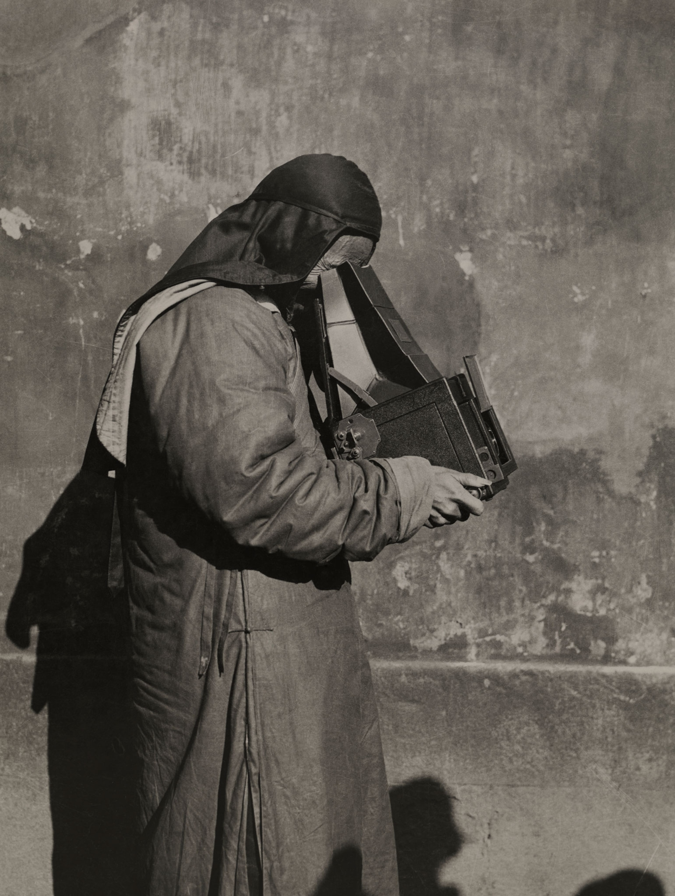 a priest looking into a camera.