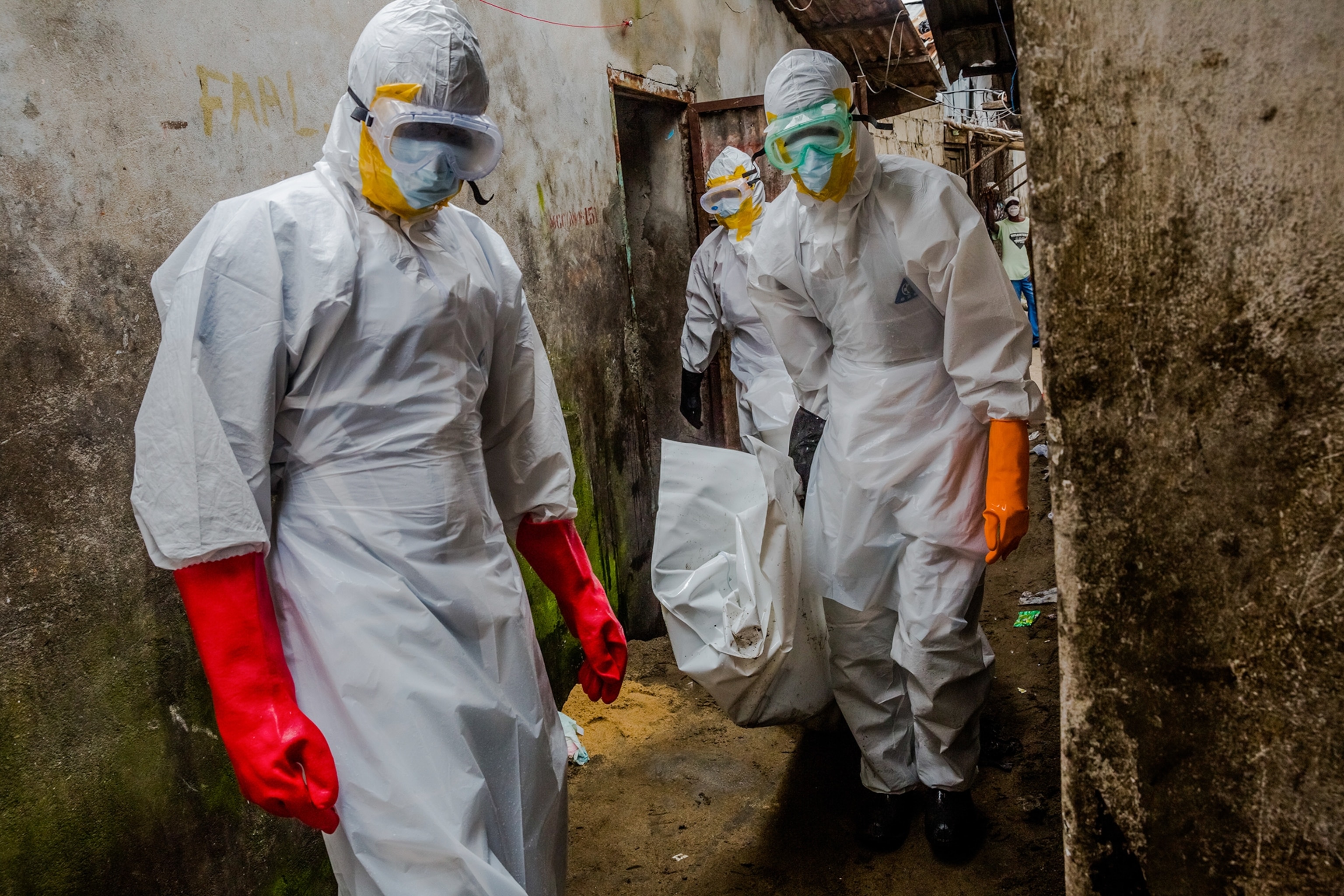 a burial team carrying the body of a suspected Ebola victim in Liberia.