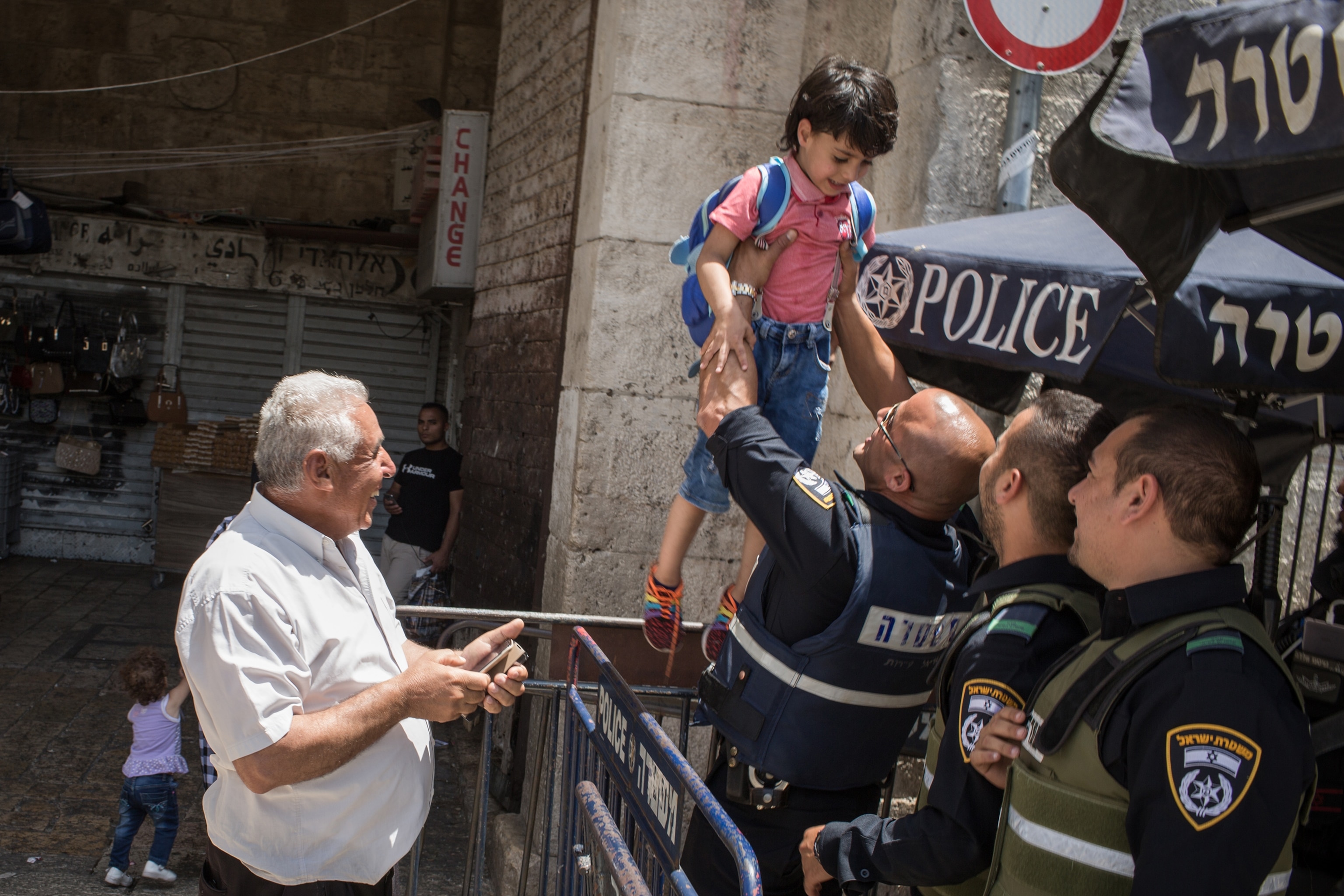 an Israeli policeman holding a Palestinian child in Jerusalem, Israel