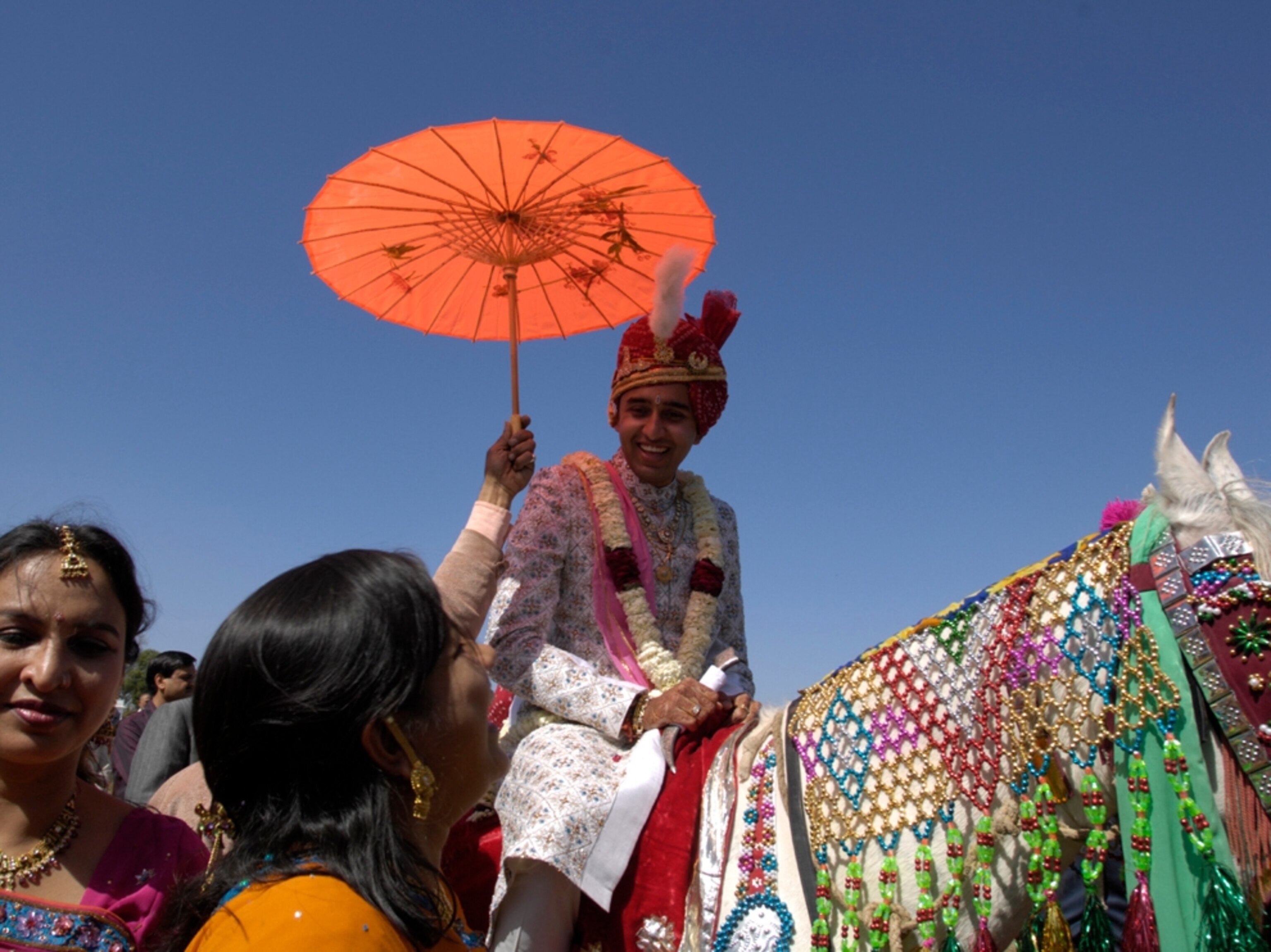 Groom on horse, baraat procession, India