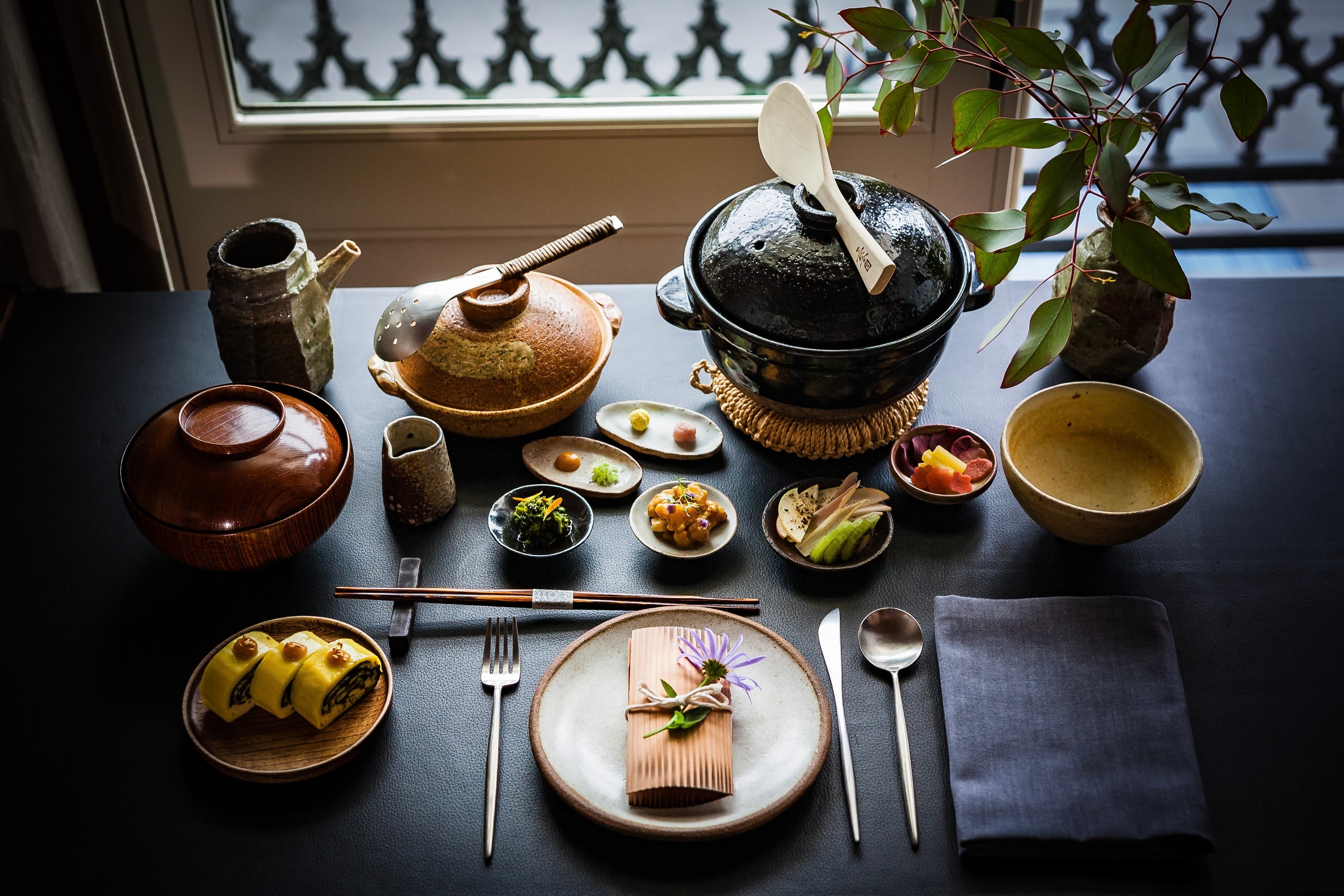 A Japanese breakfast menu with multiple small dishes and tea.