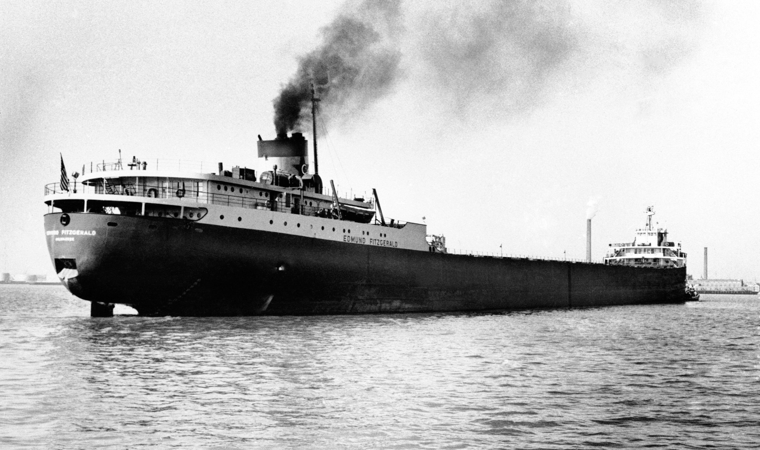 A cargo ship showing the name "Edmund Fitzgerald" and flying an American Flag from its stern.