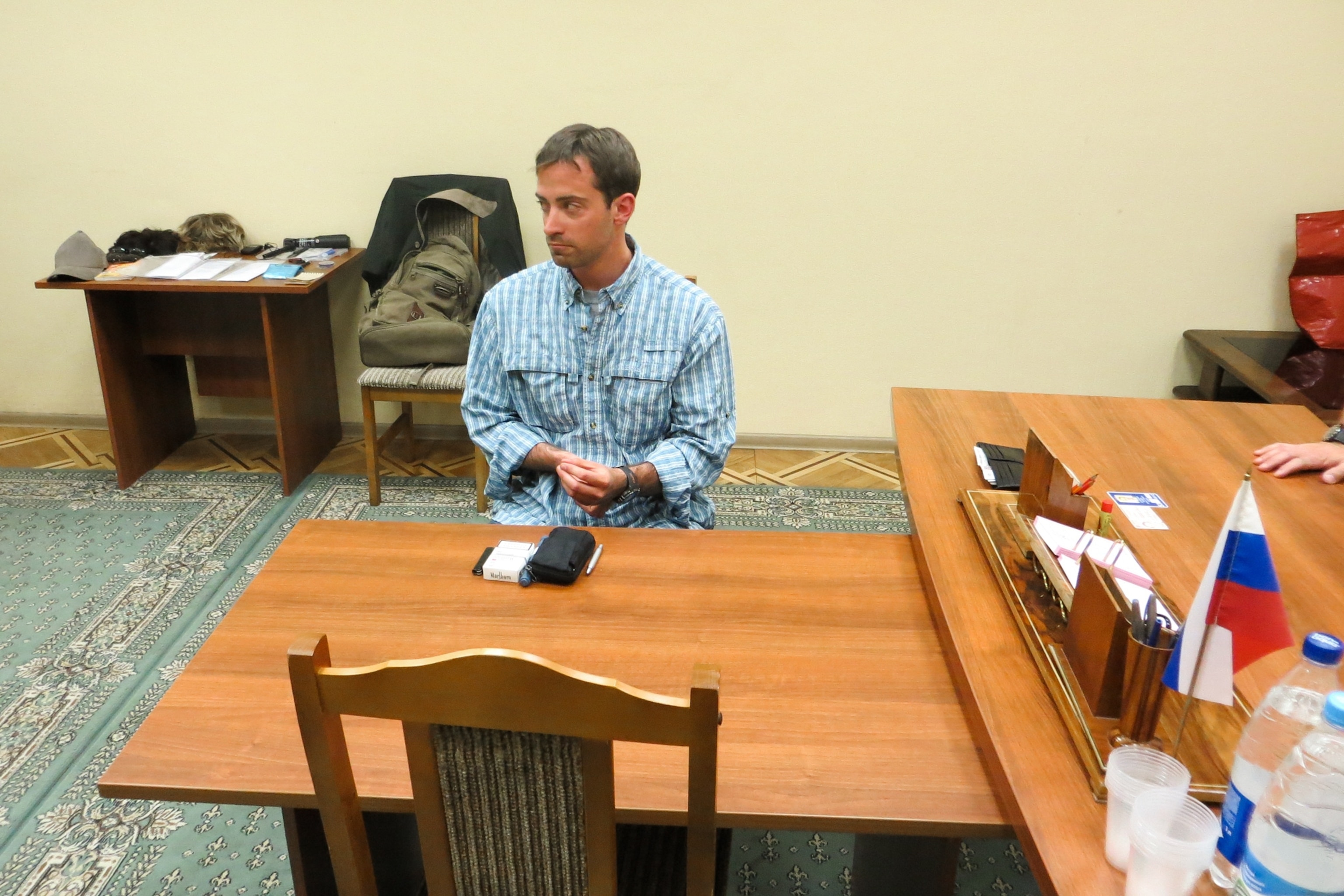 A man sits at a table in Russia.