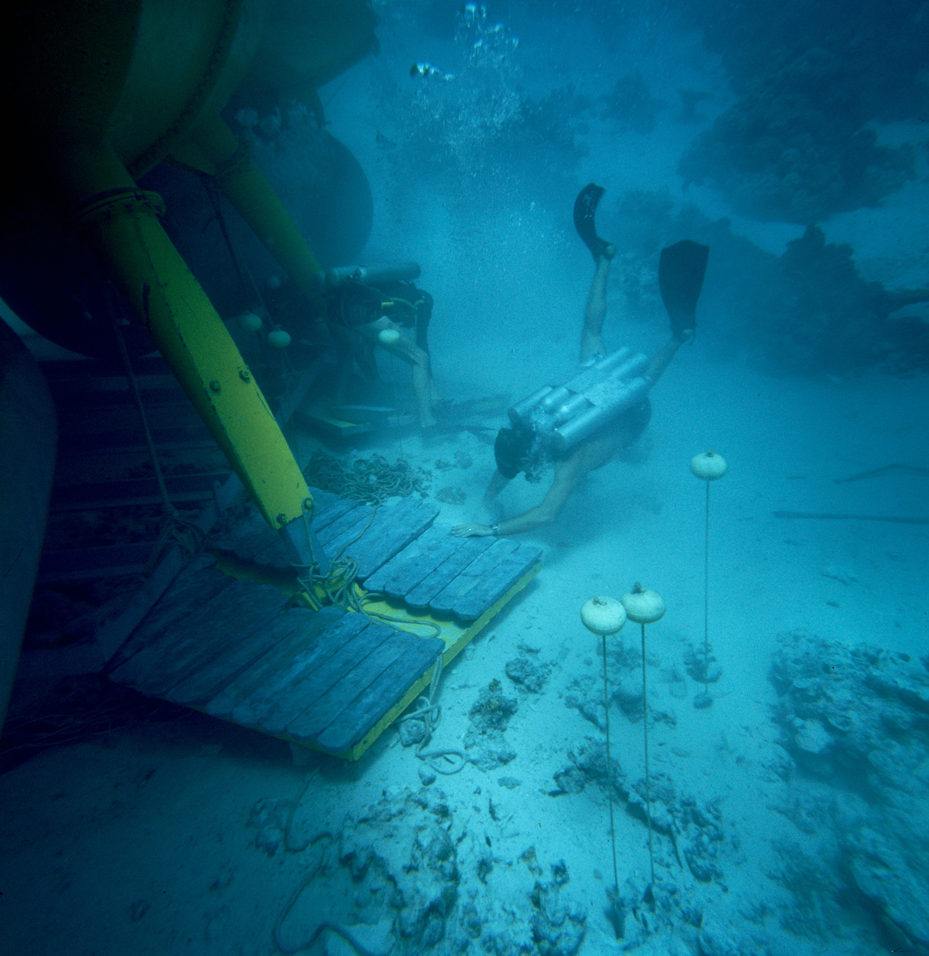 Divers heap lead onto a submersible's feet to anchor the vessel.