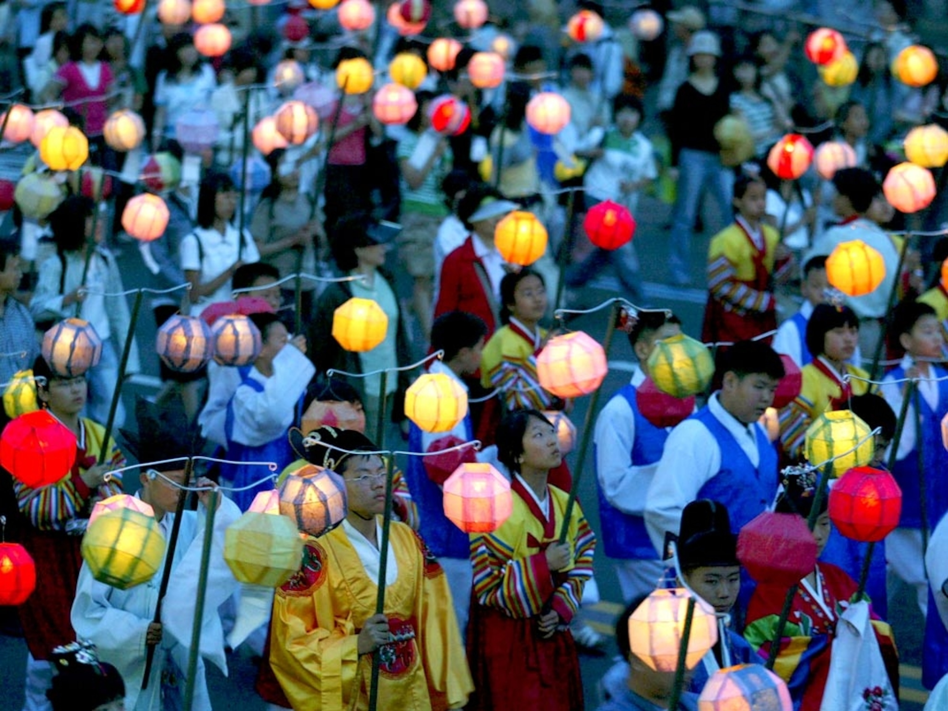 Buddhists parading with lighted paper lanterns