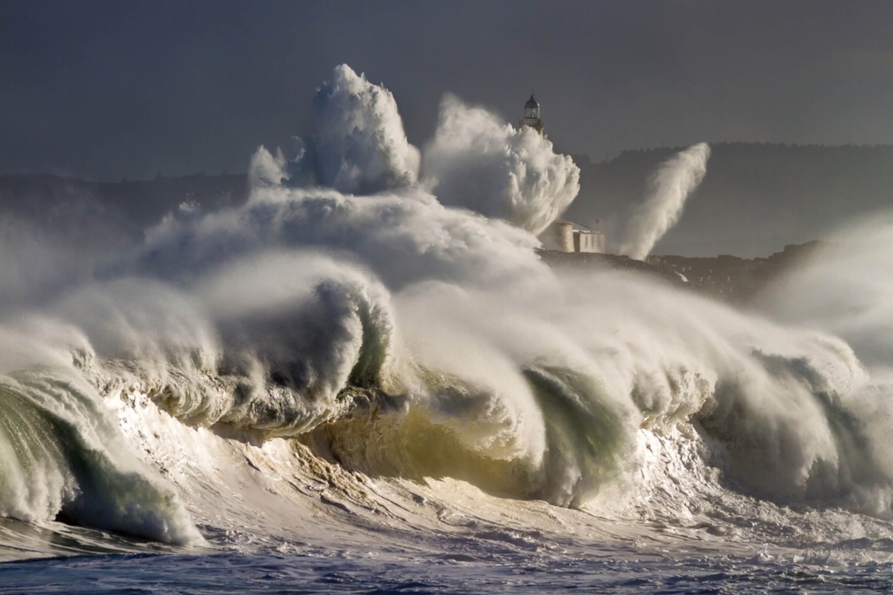 waves crashing near lighthouse at Mouro Island, Spain
