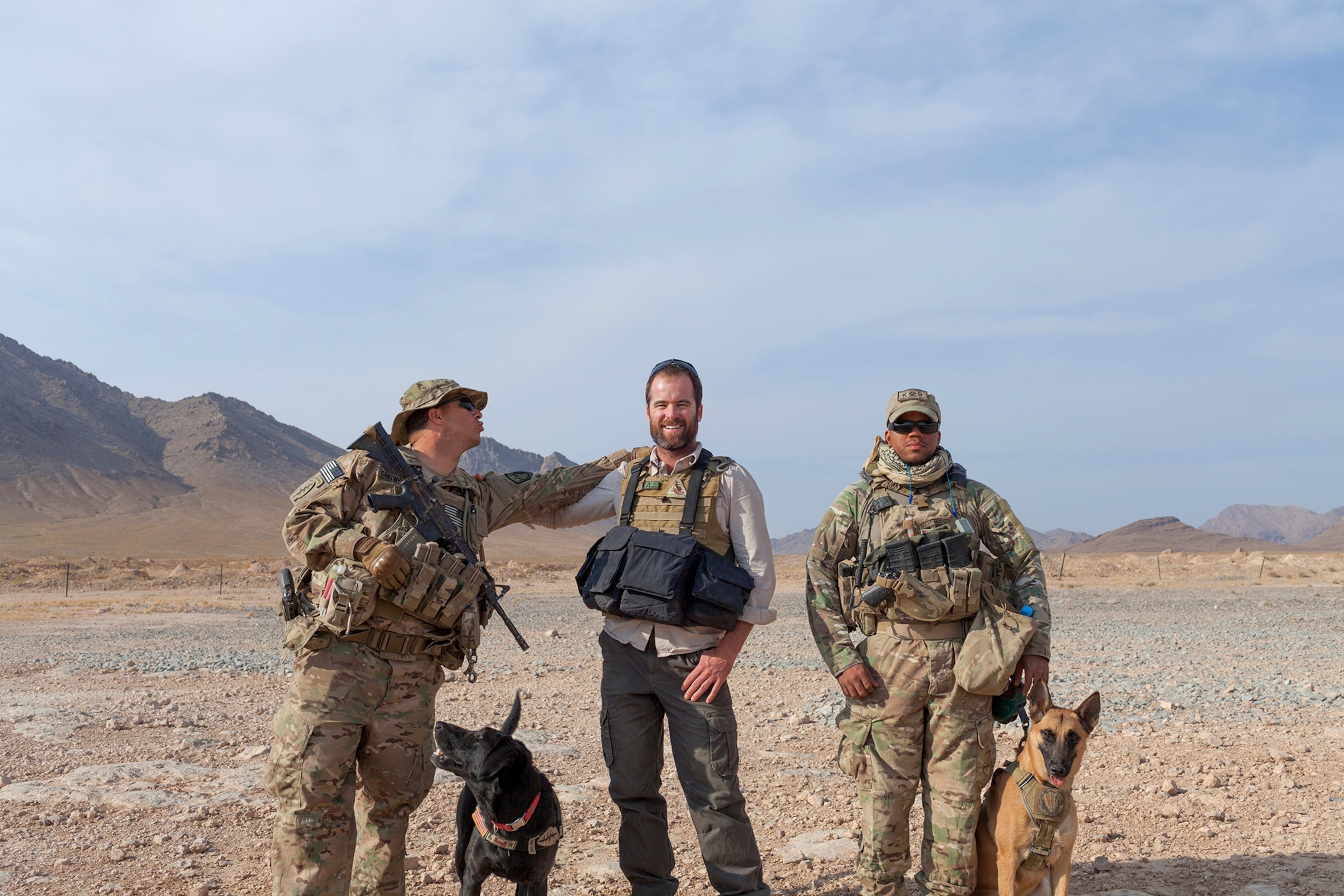 three men with two soldier dogs