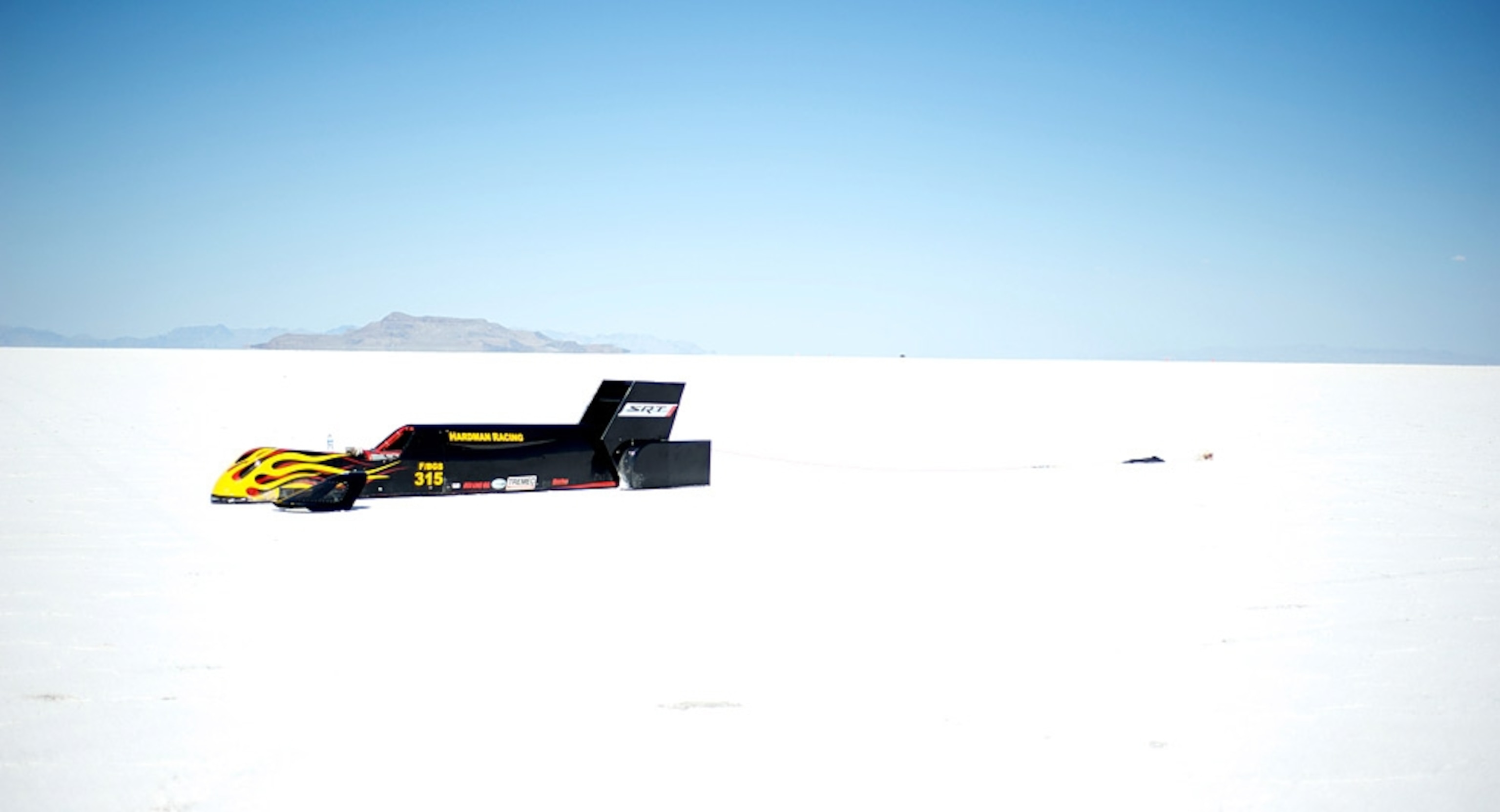 Black race car on bright white salt flats