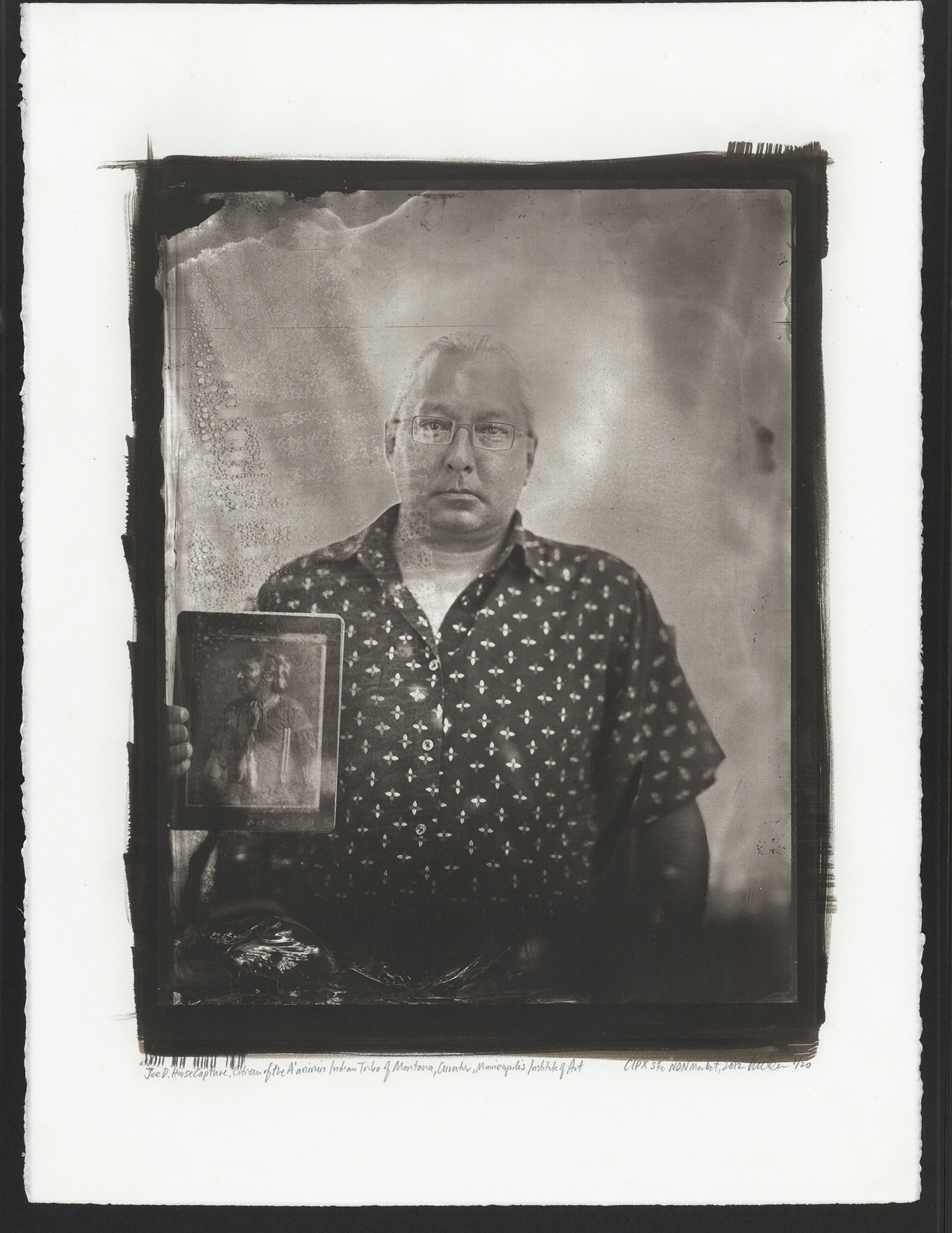 Joe D. Horse Capture, Citizen of the A’aninin Indian Tribe of Montana and Associate Curator of Native American Art, Minneapolis Institute of Art, holding an iPad displaying an image of his great great grandfather