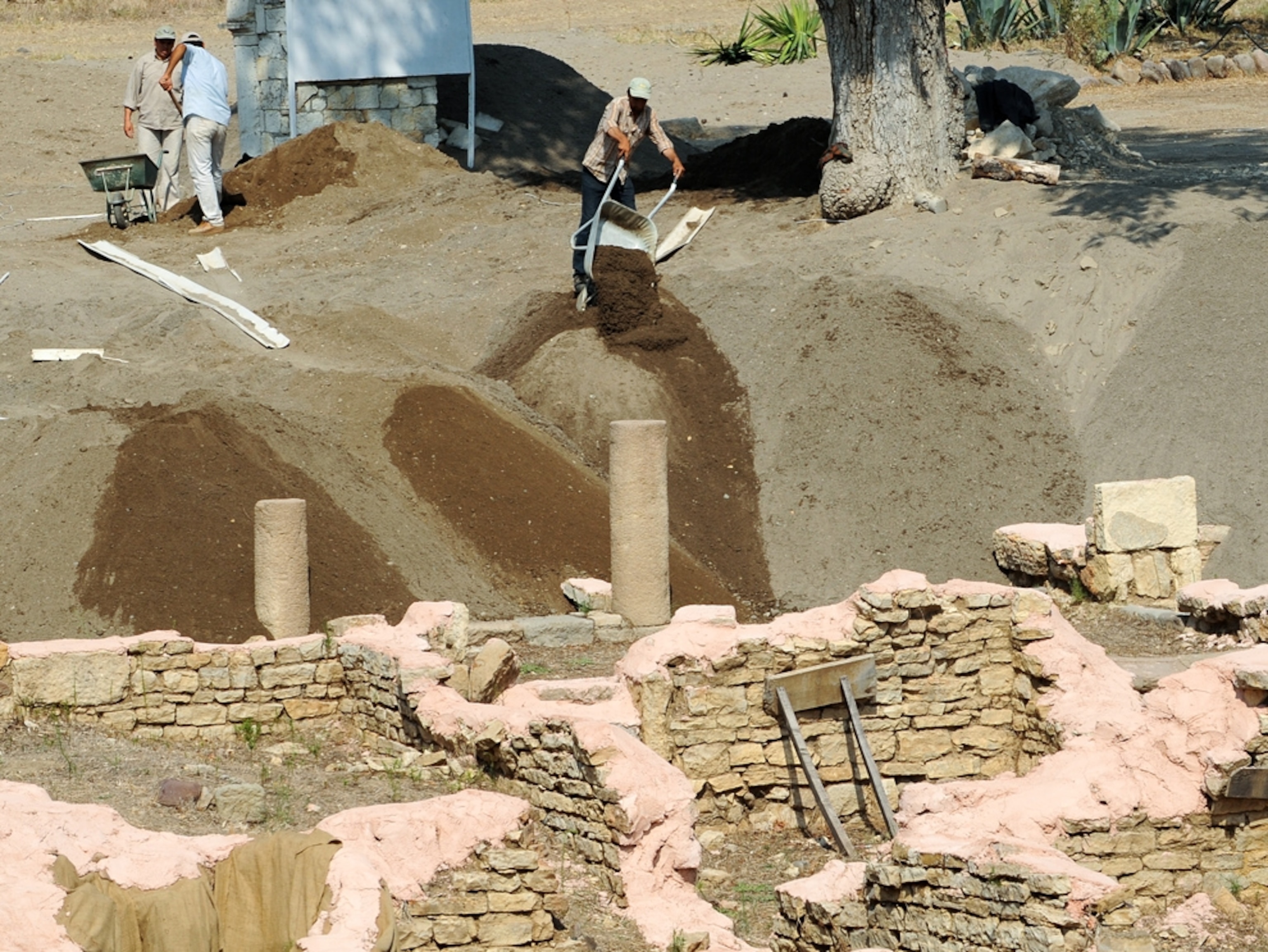 Workers dump wheelbarrows of sand on the Roman ruins at Allianoi.